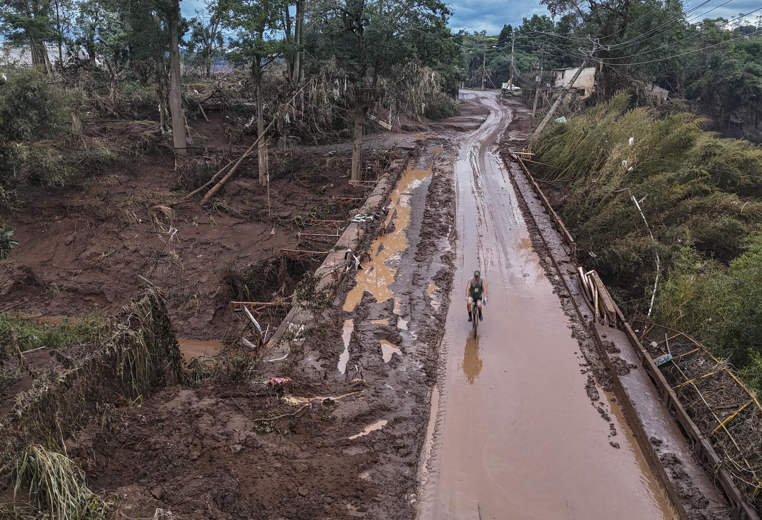 Fotografía tomada con un dron que muestra un ciclista pasando por el puente tras inundación causada por el desbordamiento del río Taquari, en la ciudad de Lajeado en el estado de Rio Grande do Sul en el sur de Brasil. (EFE/Sebastião Moreira)