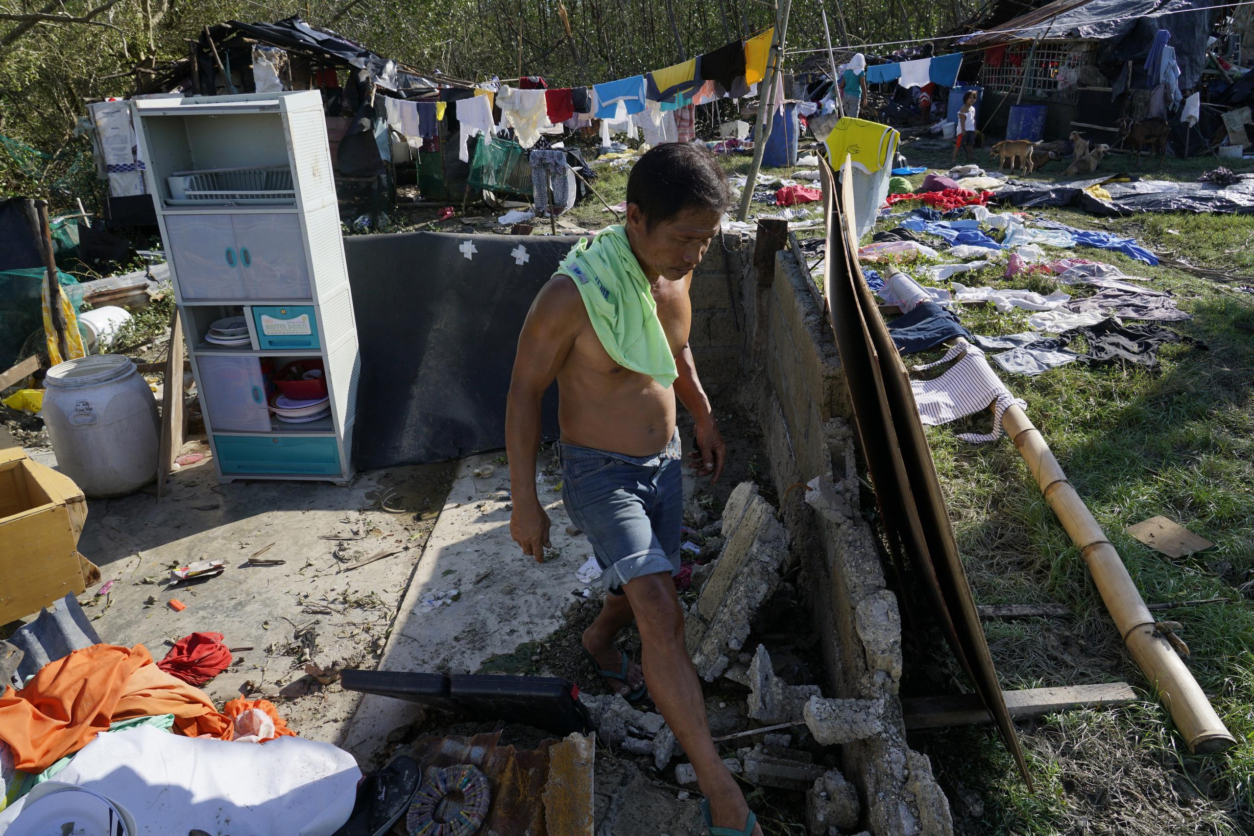 Un hombre camina entre casas derribadas por el tifón Rai en Talisay, provincia de Cebú, en el centro de Filipinas, el sábado 18 de diciembre de 2021. El fuerte tifón envolvió pueblos en inundaciones que atraparon a los residentes en los techos, derribaron árboles y cortaron la energía en el sur y la isla central. provincias, donde más de 300,000 aldeanos habían huido a un lugar seguro antes del ataque, dijeron las autoridades. (Foto AP / Jay Labra)