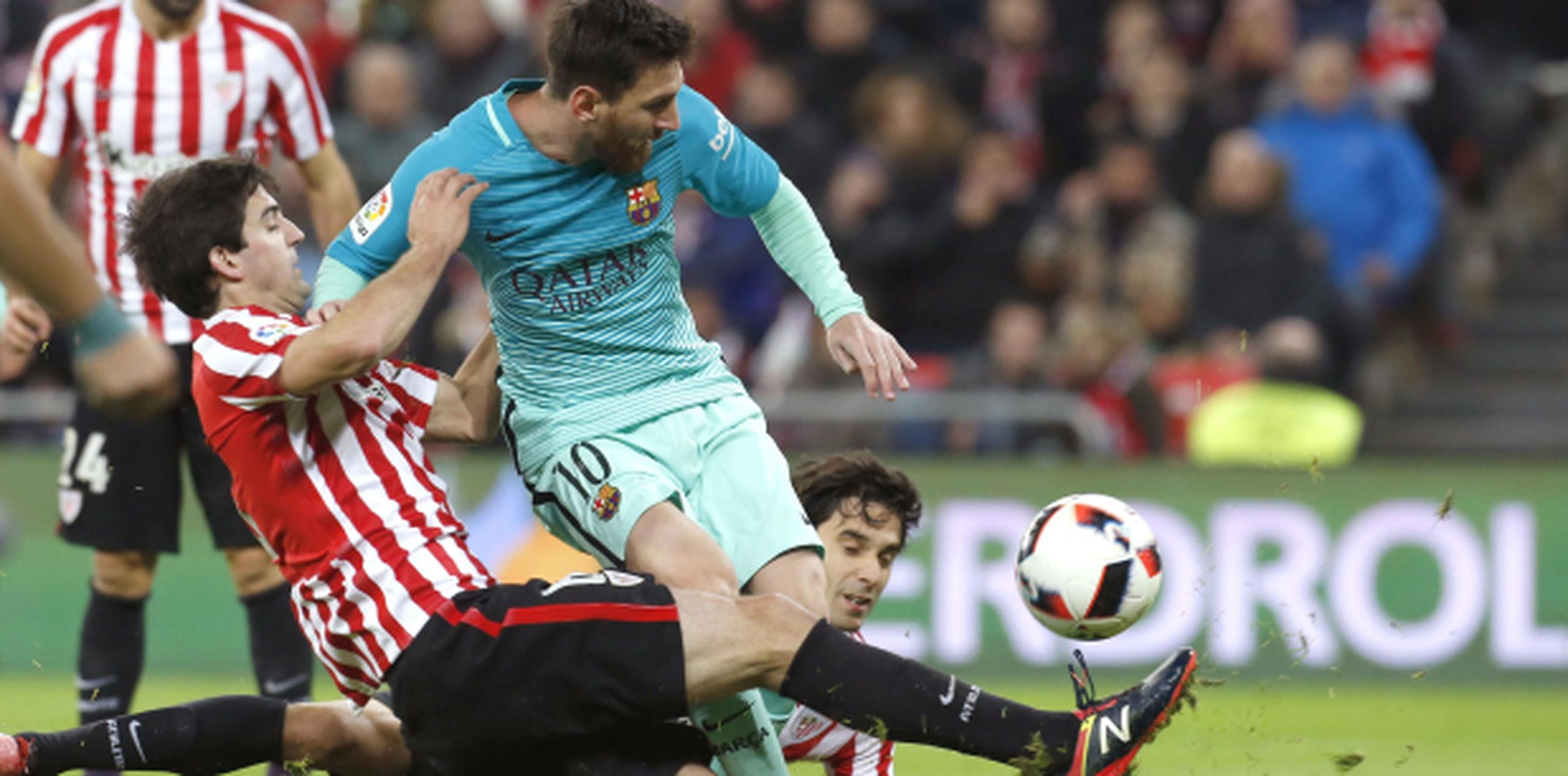 El delantero argentino del F.C Barcelona, Leo Messi, disputa un balón ante los jugadores del Athletic de Bilbao, Mikel San José y Xabier Etxeita. (Agencia EFE)