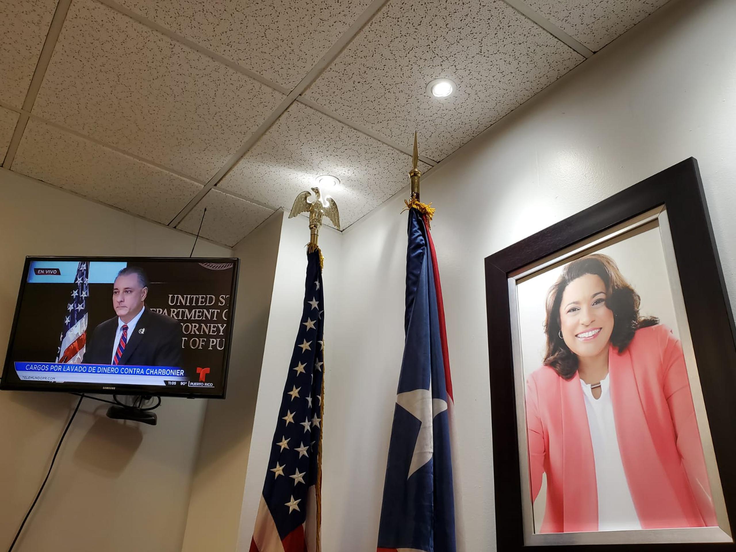 La conferencia de prensa del FBI sobre la acusación federal contra la representante, María Milagros "Tata" Charbonier, se proyectaba en su oficina en la que reinaba el silencio.