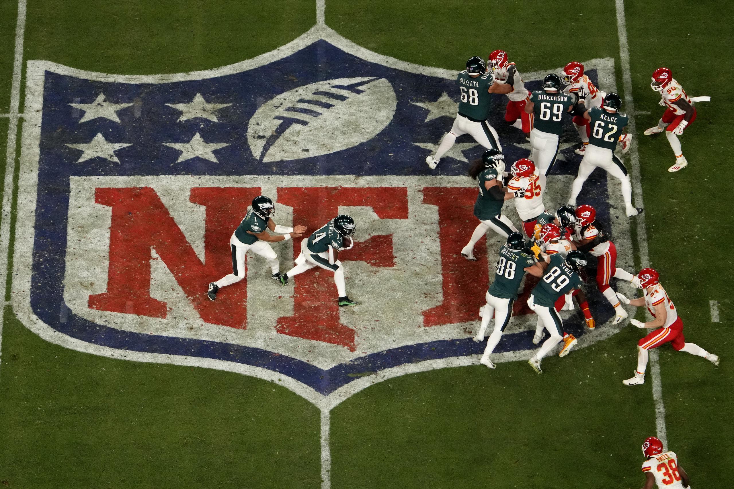 El quarterback Jalen Hurts (izquierda) de los Eagles de Filadelfia entrega el balón al running back Kenneth Gainwell (14) durante el Super Bowl 57.