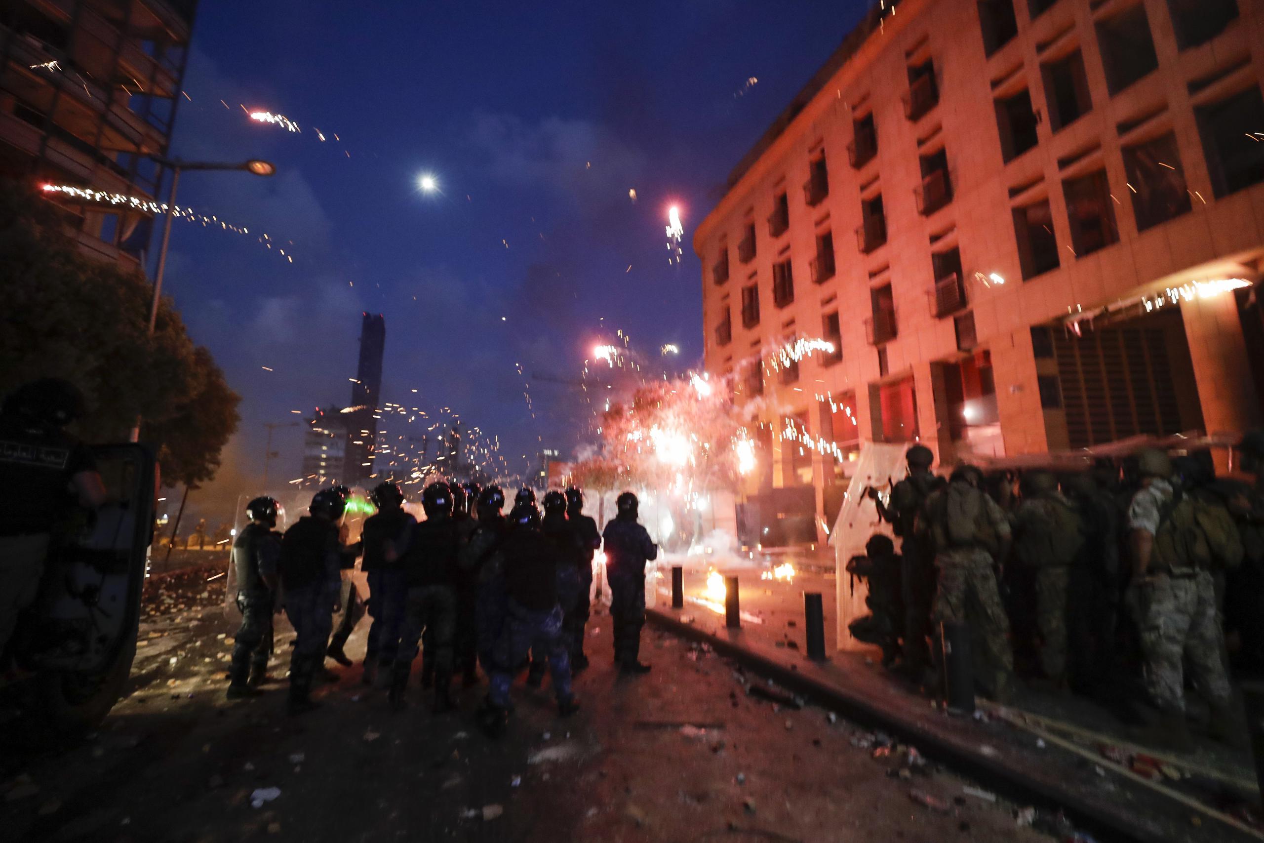 Manifestantes se enfrentan con la policía durante una protesta contra el gobierno después de la explosion del martes en el puerto de Beirut