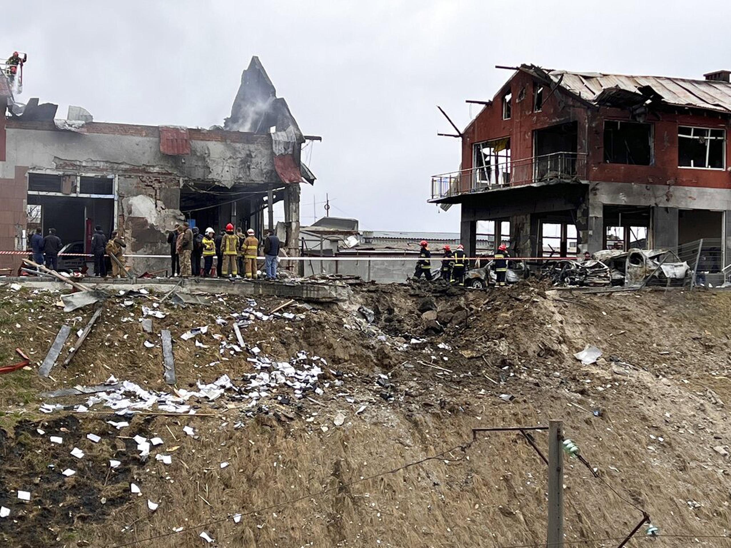 Personal de emergencia limpia los escombros después de un ataque aéreo en un establecimiento de neumáticos en la ciudad occidental de Leópolis, Ucrania, el 18 de abril de 2022.
