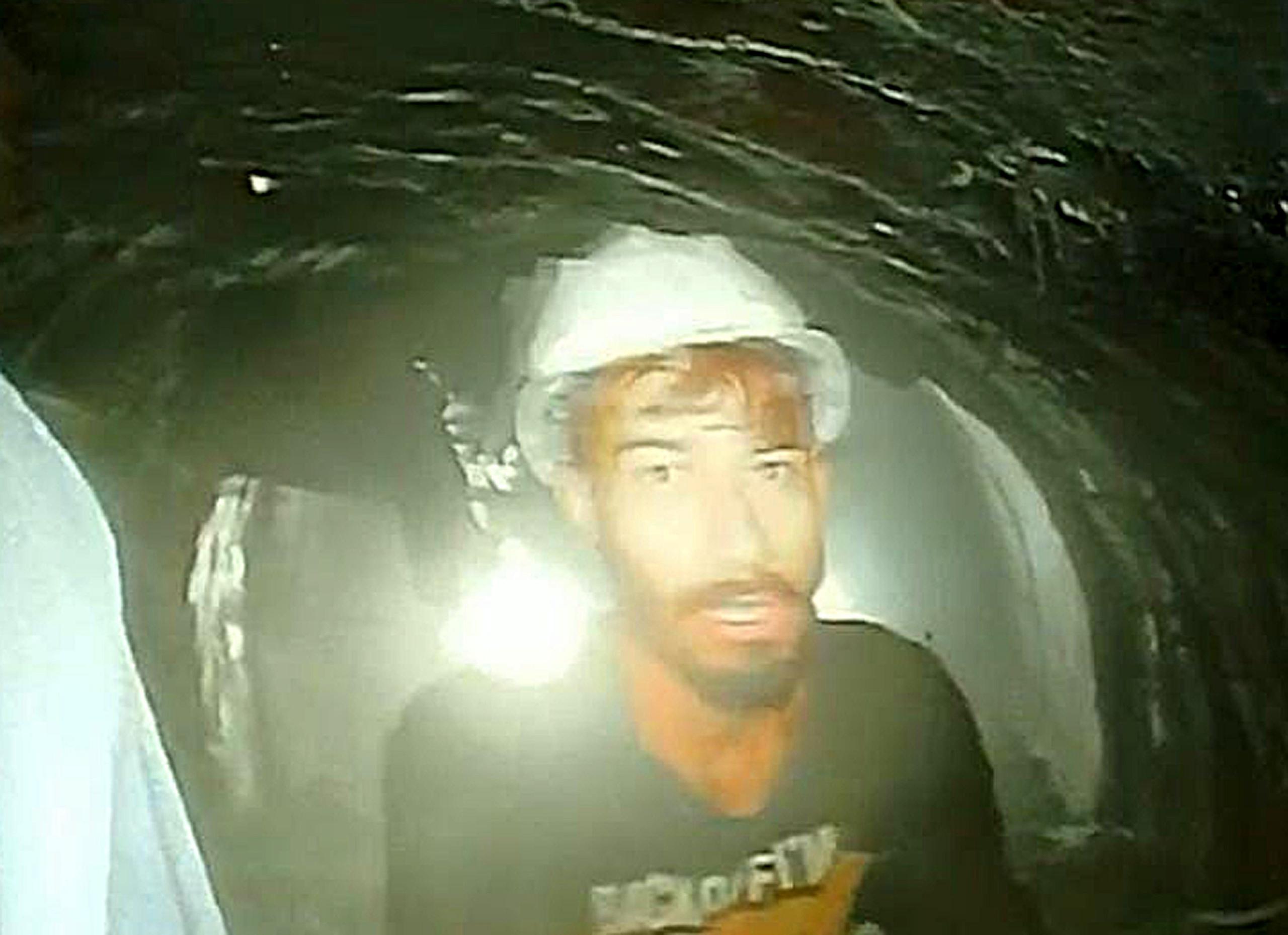 El vídeo muestra a un grupo de obreros, primero sacando la cámara de la tubería y luego agrupados en torno a ella, en el interior de un túnel iluminado por varios potentes focos.