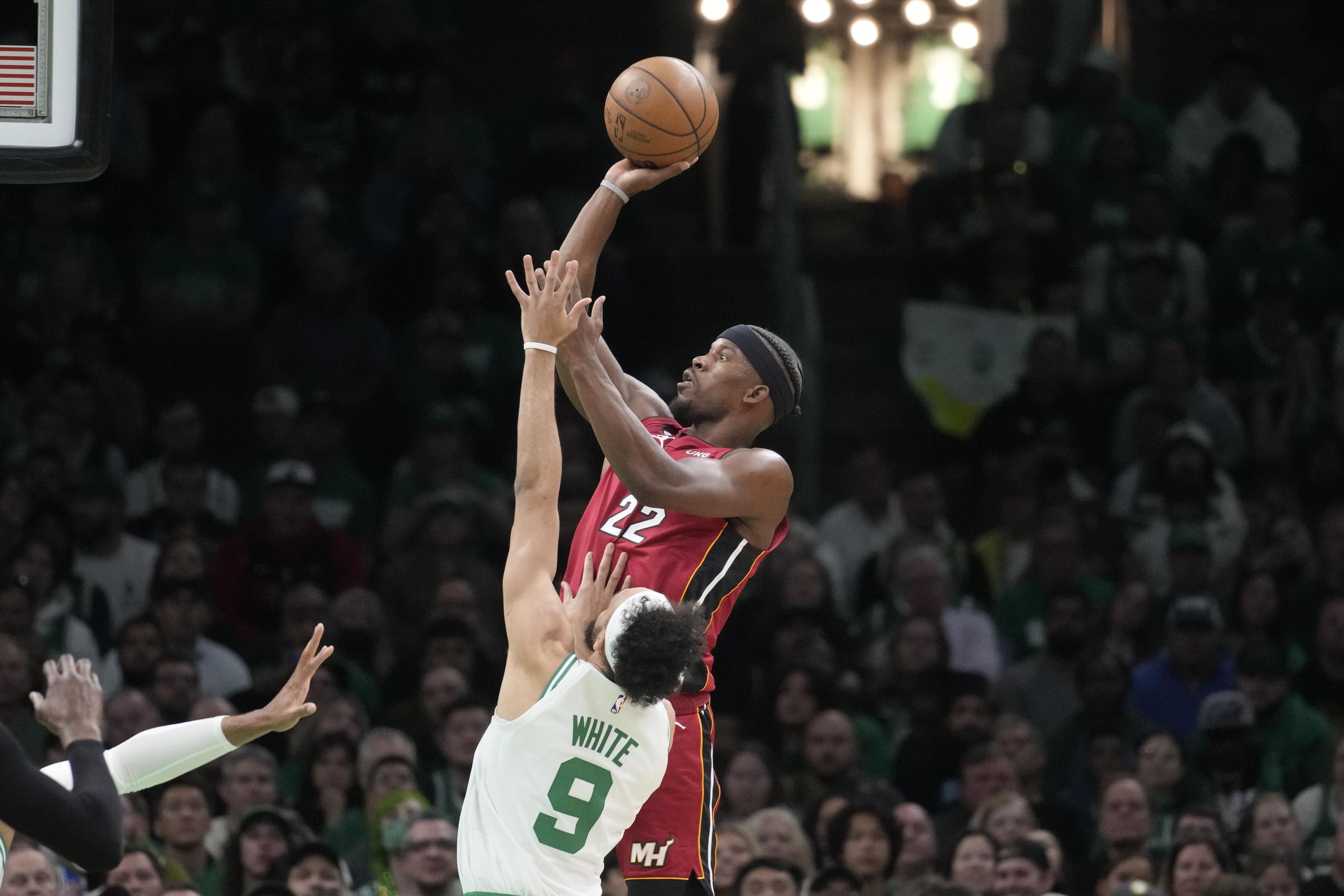 El delantero del Heat de Miami, Jimmy Butler, se levanta para realizar un intento ante Derrick White, de los Celtics.