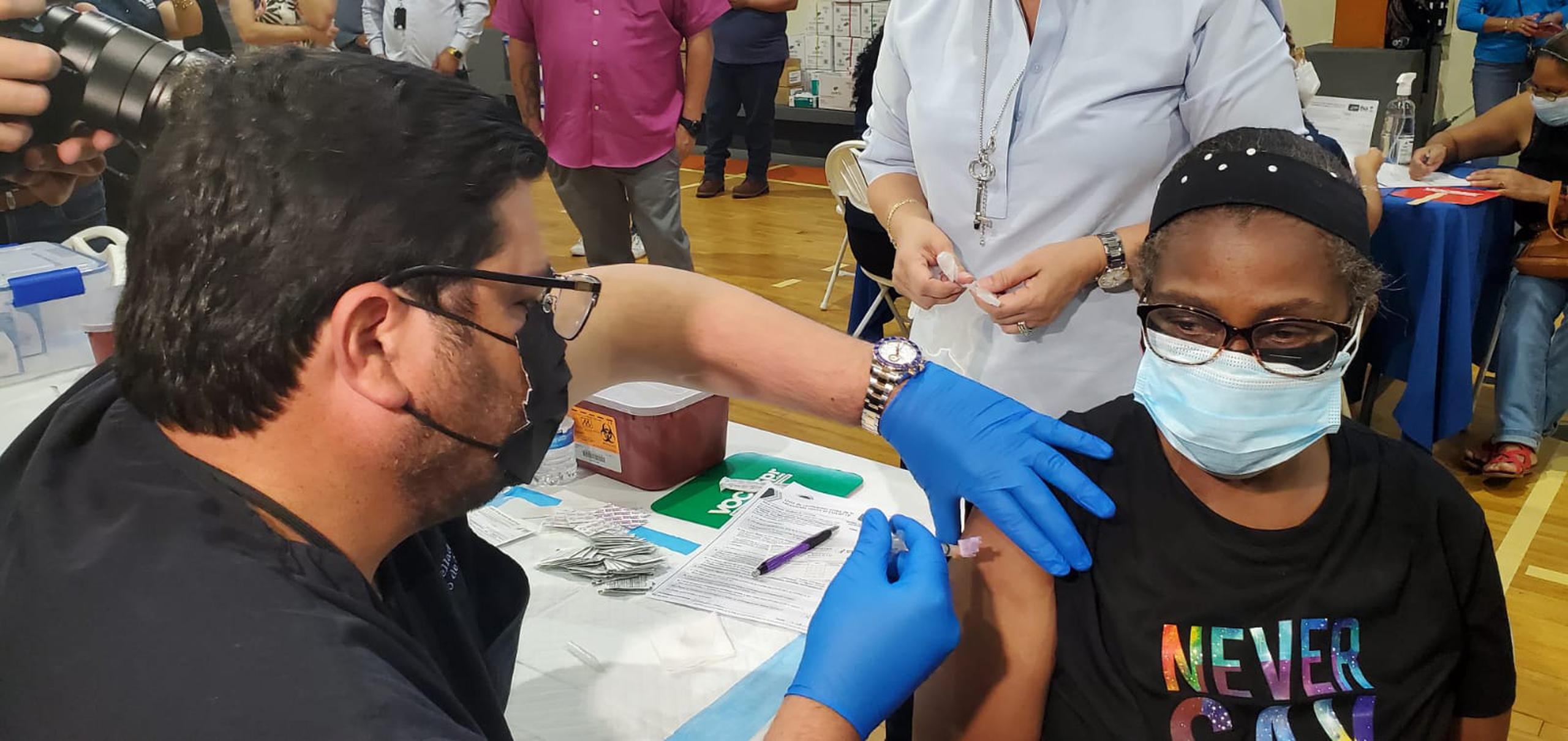 El secretario de Salud, Carlos Mellado, vacuna a Wanda Romero en una actividad realizada en el residencial Luis Llorens Torres de Santurce.