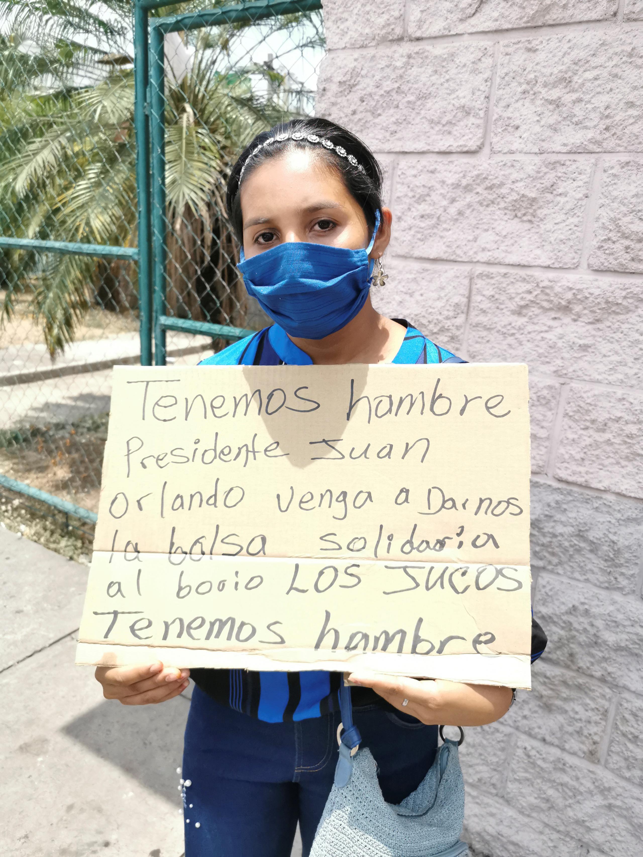 La residente hondureña Damaris Perdomo pide ayuda para comida ayer lunes, en una calle de Tegucigalpa (Honduras).