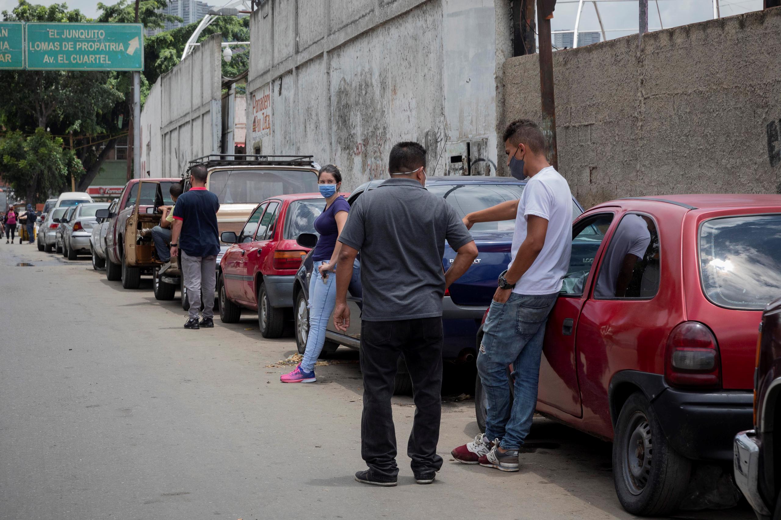 Personas esperan para obtener gasolina subsidiada, en una calle de Caracas (Venezuela).