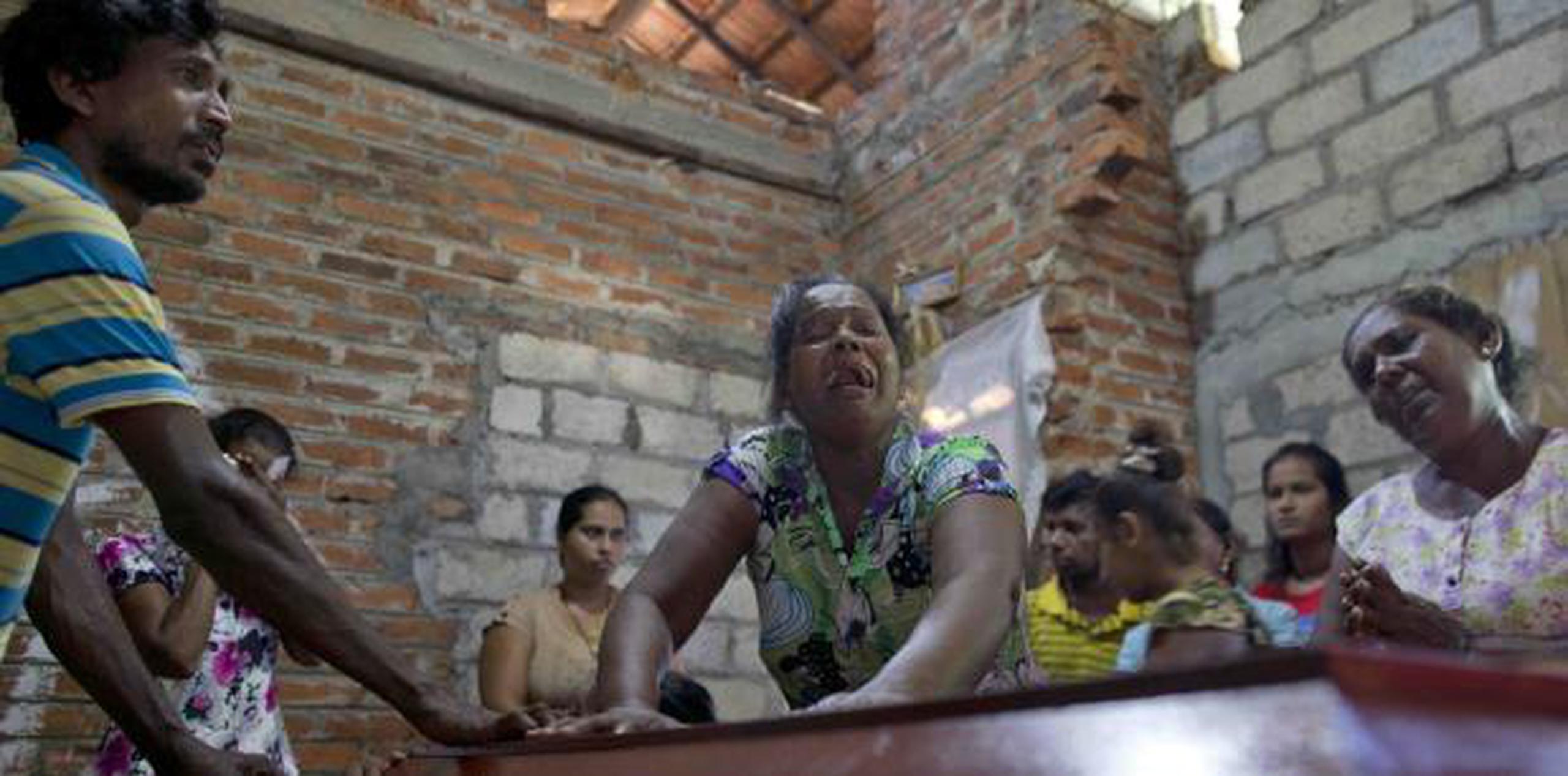 Una mujer llora ante el ataúd de su sobrina de 12 años, una de las casi 300 asesinadas por extremistas religiosos en Sri Lanka. (AP)