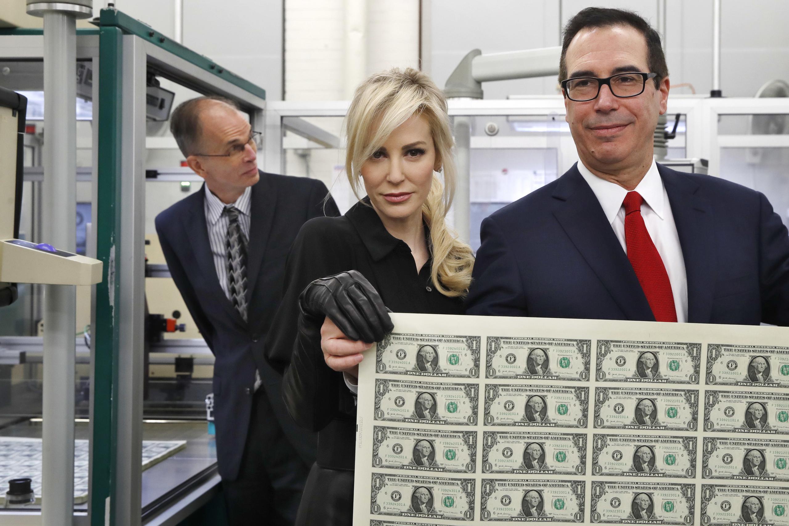 El secretario del Tesoro, Steven Mnuchin, y su esposa Louise Linton, con una hoja de billetes de un dólar. (AP / Jacquelyn Martin)