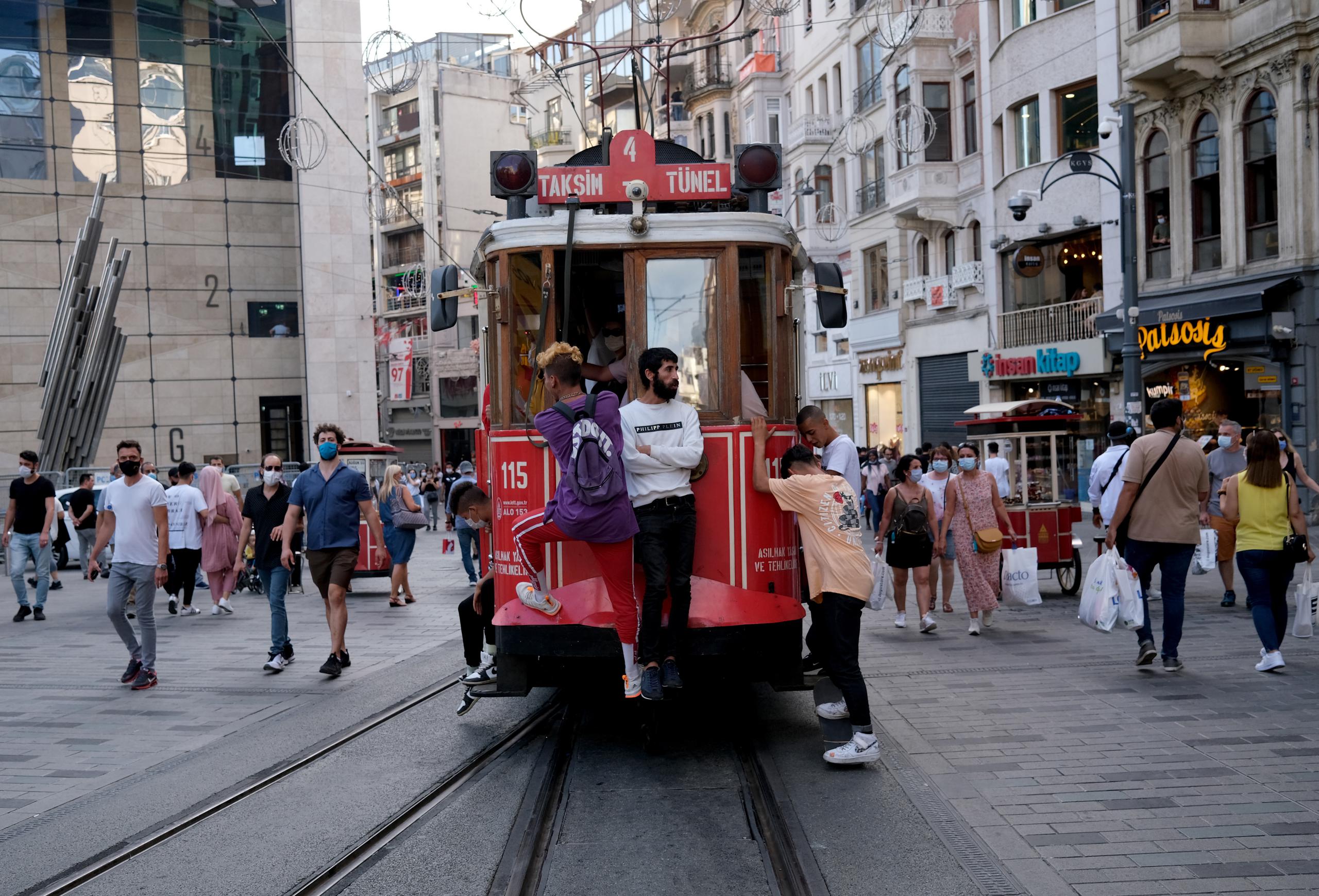 Personas caminan y viajan en tranvía en una calle de Estambul. EFE/EPA/SEDAT SUNA/ARCHIVO
