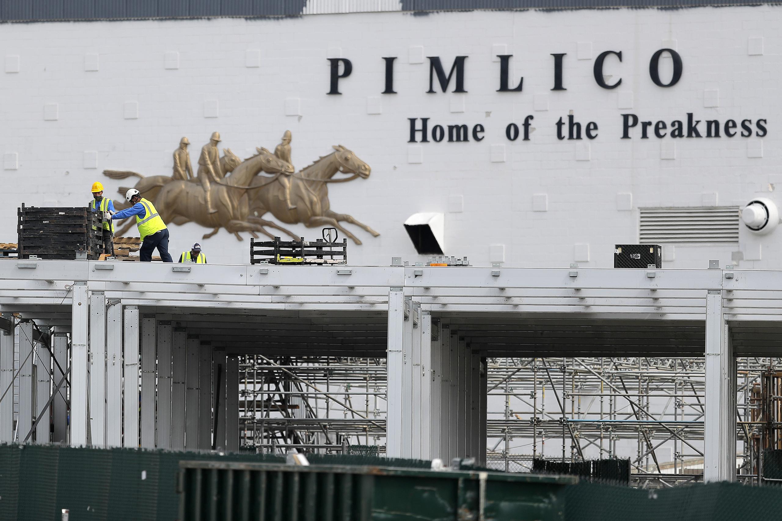 Trabajadores colocan una plataforma en la entrada principal del hipódromo Pimlico Race Course de Baltimore, el 15 de mayo de 2020, un día antes de la fecha original en que se iba a realizar aquí la carrera Preakness, que se pospuso debido a la pandemia de coronavirus.