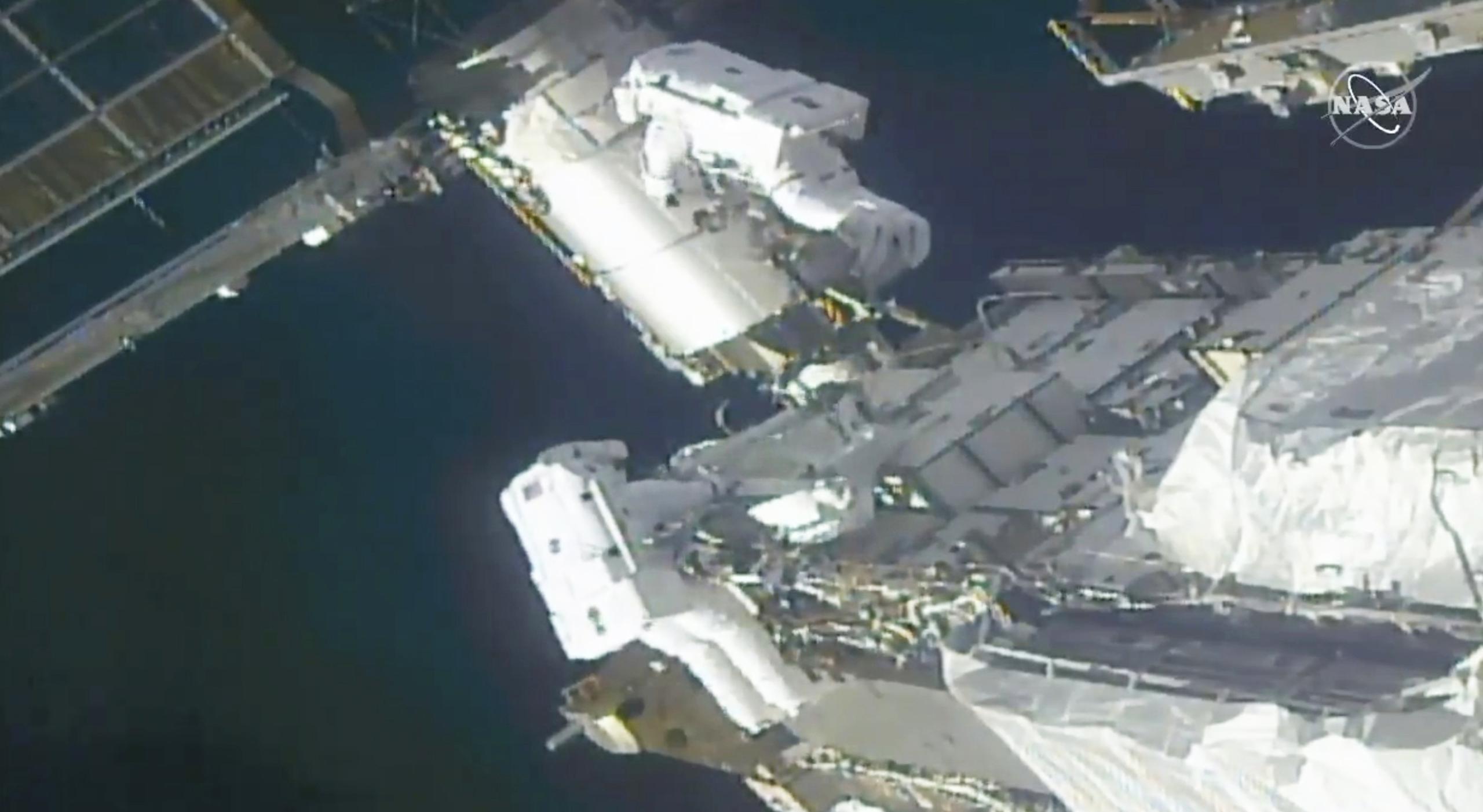 Imagen tomada de un video de la NASA, de los astronautas de la NASA Kate Rubins, arriba, y Victor Glover trabajando afuera de la Estación Espacial Internacional el domingo 28 de febrero de 2021.