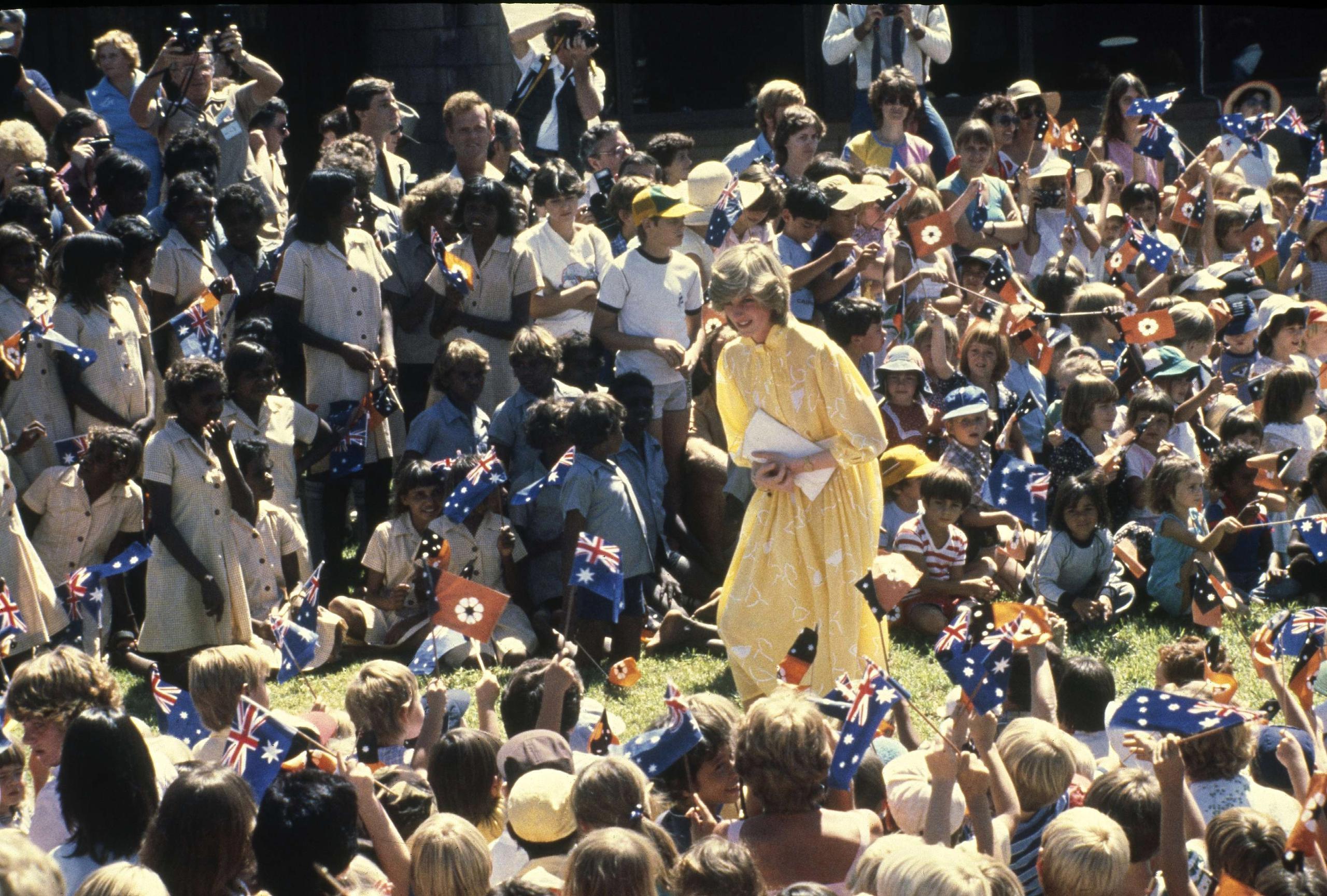 ARCHIVO – En esta fotografía del 21 de marzo de 1983 Diana la princesa de Gales entre un grupo grande de niños escolares durante su visita a Alice Springs, Australia. La princesa Diana, que era considerada tímida al saltar a la fama, se convirtió en una revolucionaria en sus años en la Casa de Windsor modernizando la monarquía como una institución más personal y cambiando la forma en la que la familia real se relacionaba con la gente. (Foto AP/Dave Caulkin, archivo)