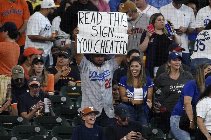 Un fanático de los Dodgers sostiene un letrero en contra de los Astros durante el partido en el Minute Maid Park de Houston.