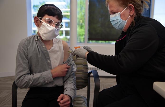 Un menor de 14 años recibe la primera dosis de la vacuna de Pfizer-BioNTech.