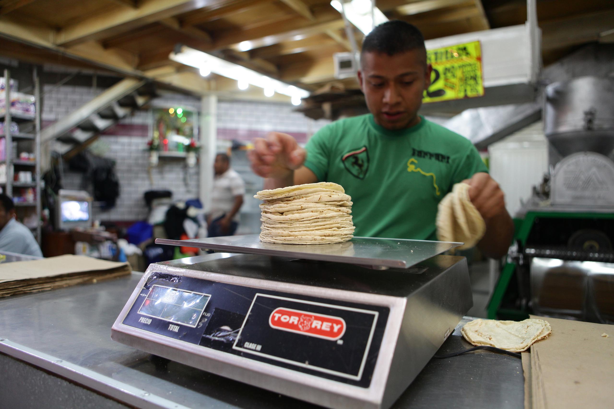 Un vendedor pesa un kilo de tortillas el 23 de febrero de 2018 en un mercado de la Ciudad de México (México). EFE/Sáshenka Gutiérrez
