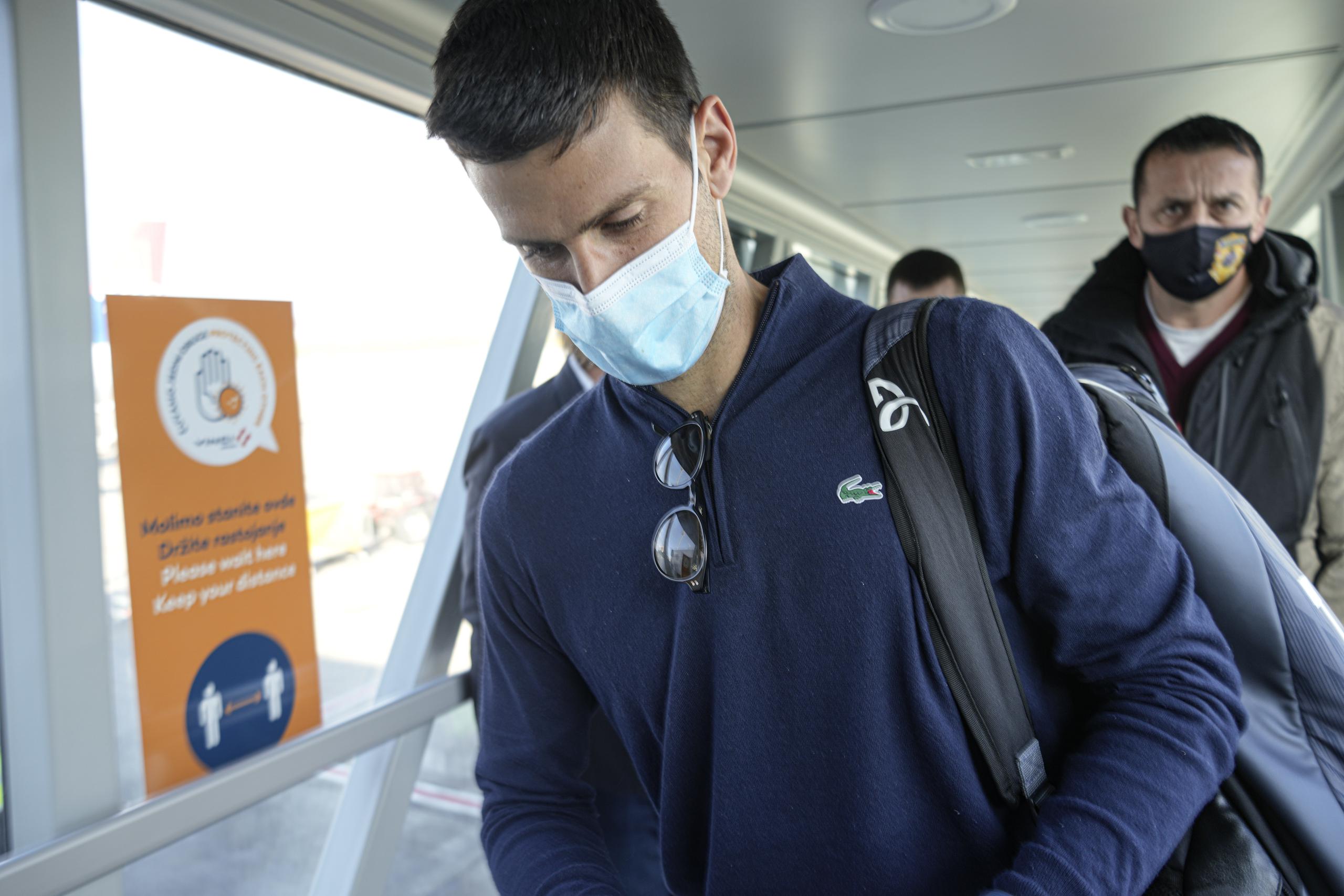 Novak Djokovic revisa sus documentos al arriba al aeropuerto de Belgrado, el lunes 17 de enero de 2022.