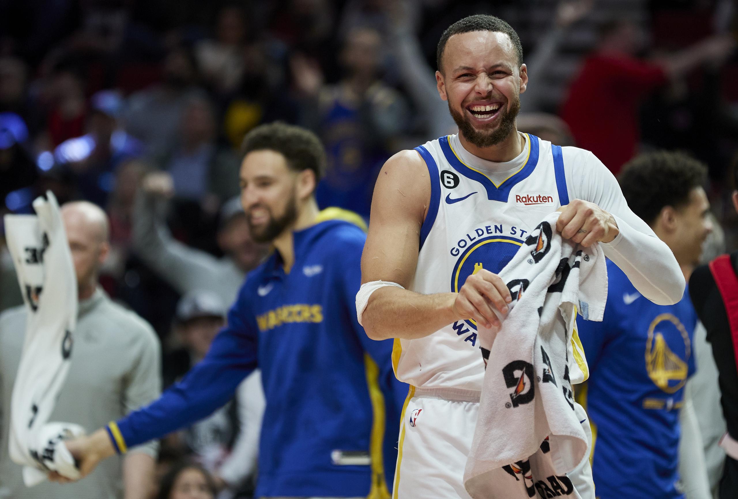 Golden State Warriors guard Stephen Curry (30) reacts after a basket by forward Jonathan Kuminga during the second half of an NBA basketball game in Portland, Ore., Sunday, April 9, 2023. (AP Photo/Craig Mitchelldyer)