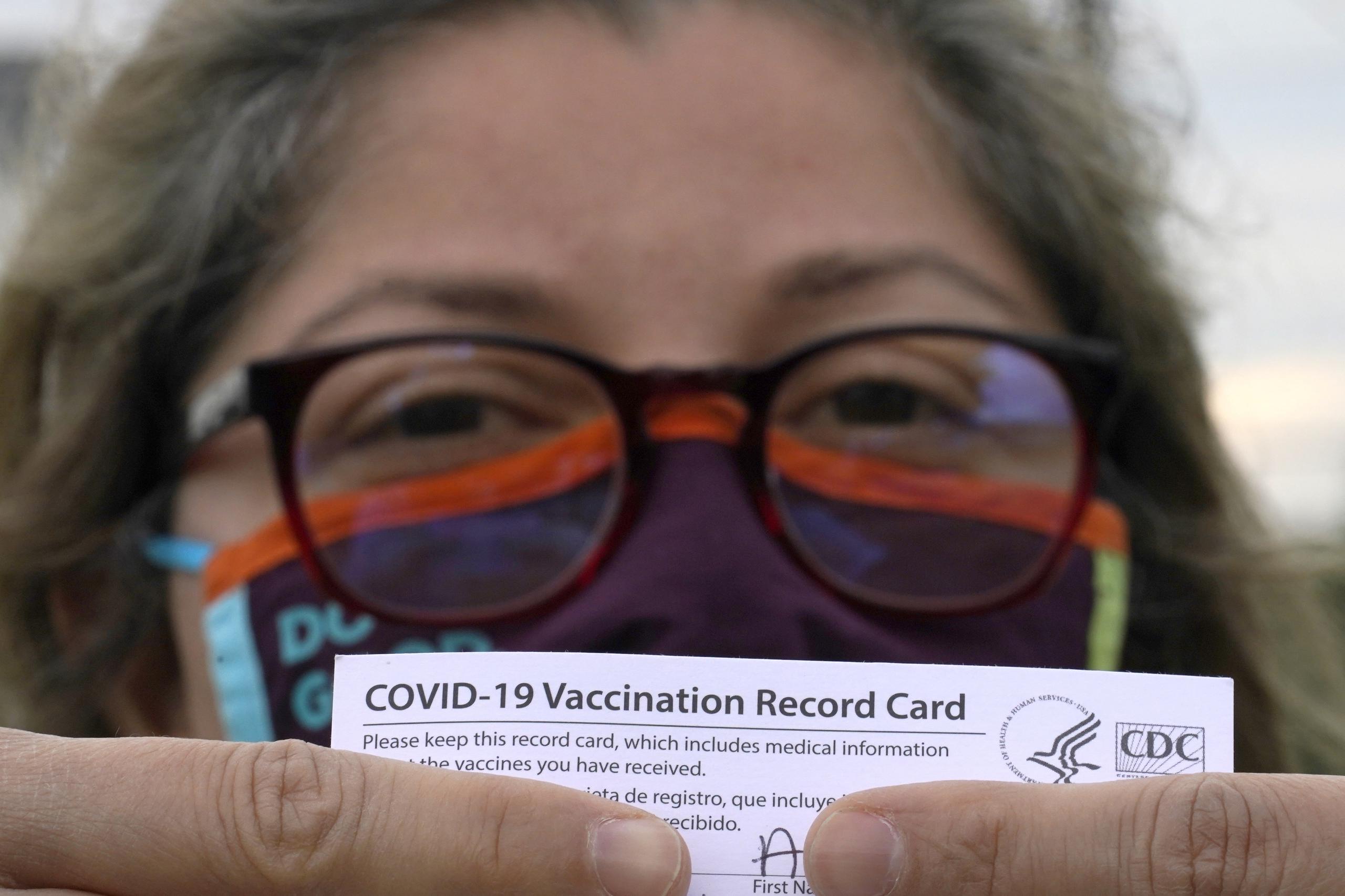 Alejandra, una dentista mexicana y que pidió no revelar su apellido, posa con su tarjeta de vacunación después de recibir la segunda dosis de la vacuna de Moderna contra el COVID-19 en Pasadena, Texas.