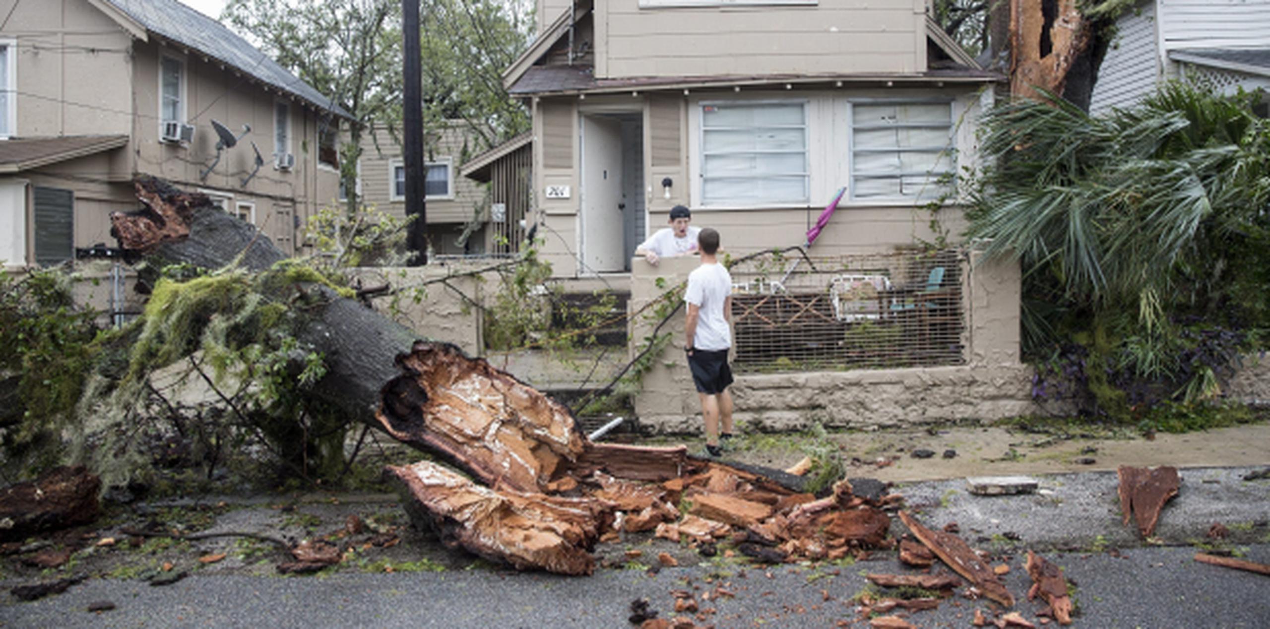 Micah Beemon (izquierda) conversa con un vecino sobre el gran árbol que cayó frente a su patio en Daytona Beach, Florida. (EFE / EPA / Willie J. Allen Jr.)