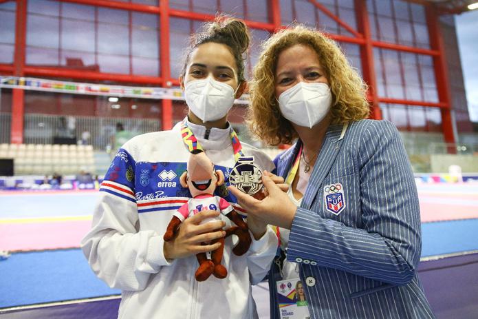 La taekwondoísta Gianna Vega Ortiz muestra su medalla de plata junto a la presidenta del Comité Olímpico de Puerto Rico, Sara Rosario.