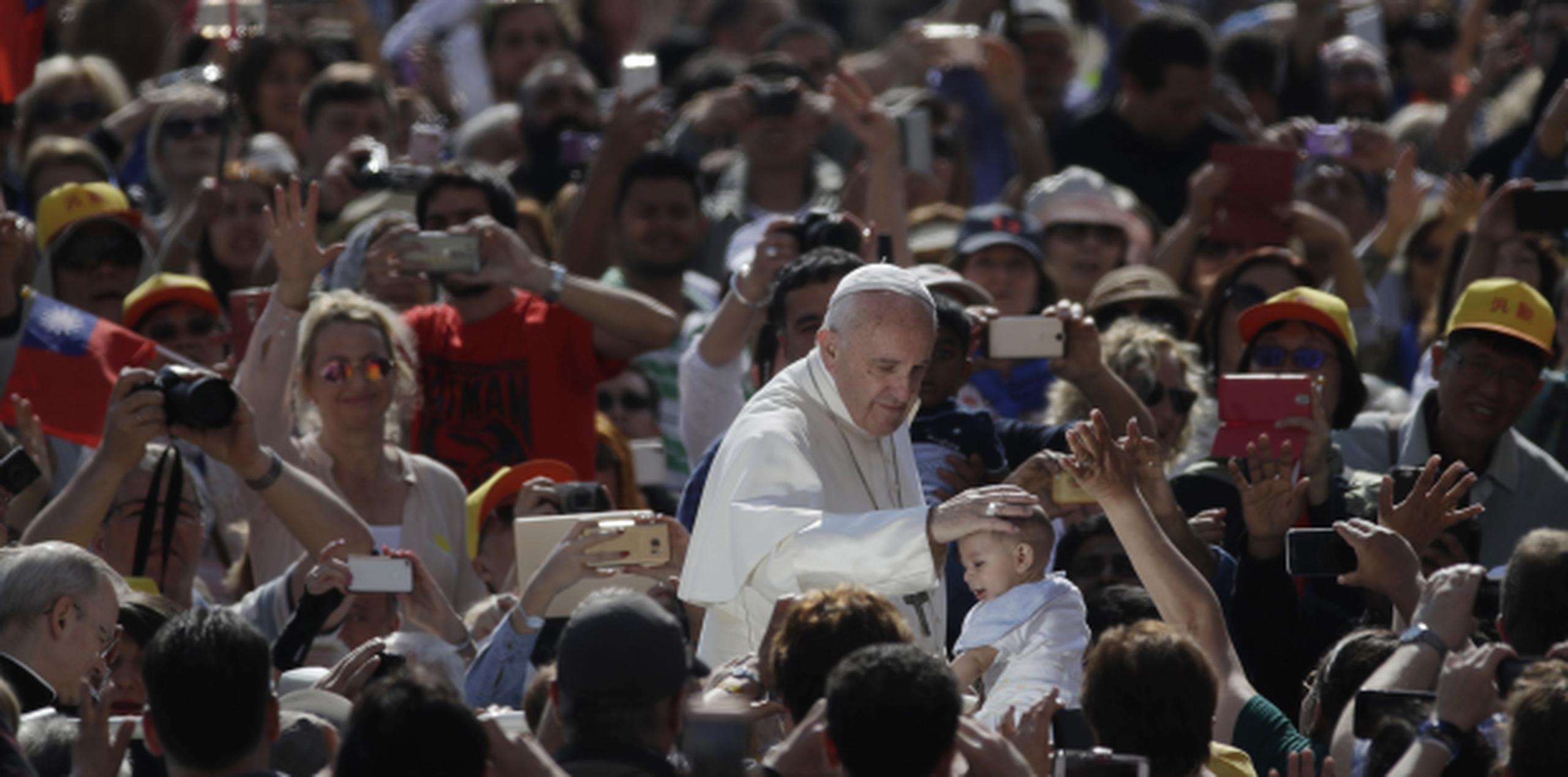 El papa acaricia a un niño hoy en la Plaza San Pedro. (AP)