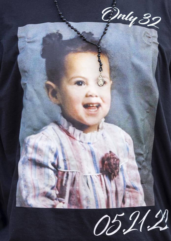 Enrique Owens, un primo de Roberta Drury, lleva una camiseta con una fotografía de ella cuando era pequeña antes de su funeral, el sábado 21 de mayo de 2022, en Syracuse, Nueva York.