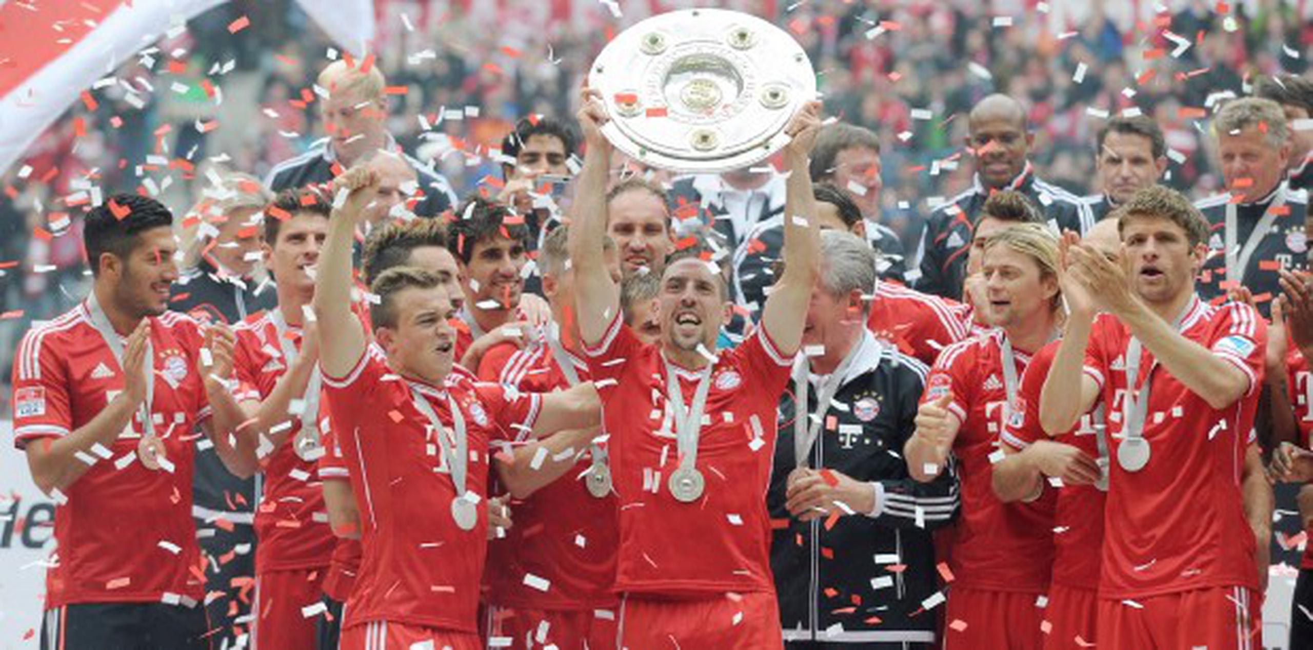 El astro francés Franck Ribery levanta el trofeo de la Bundesliga hoy, luego de la victoria del Bayern Munich, 3-0, sobre el Augsburgo para convertirse en campeones de la liga alemana. (Tobias Hase / EFE).
