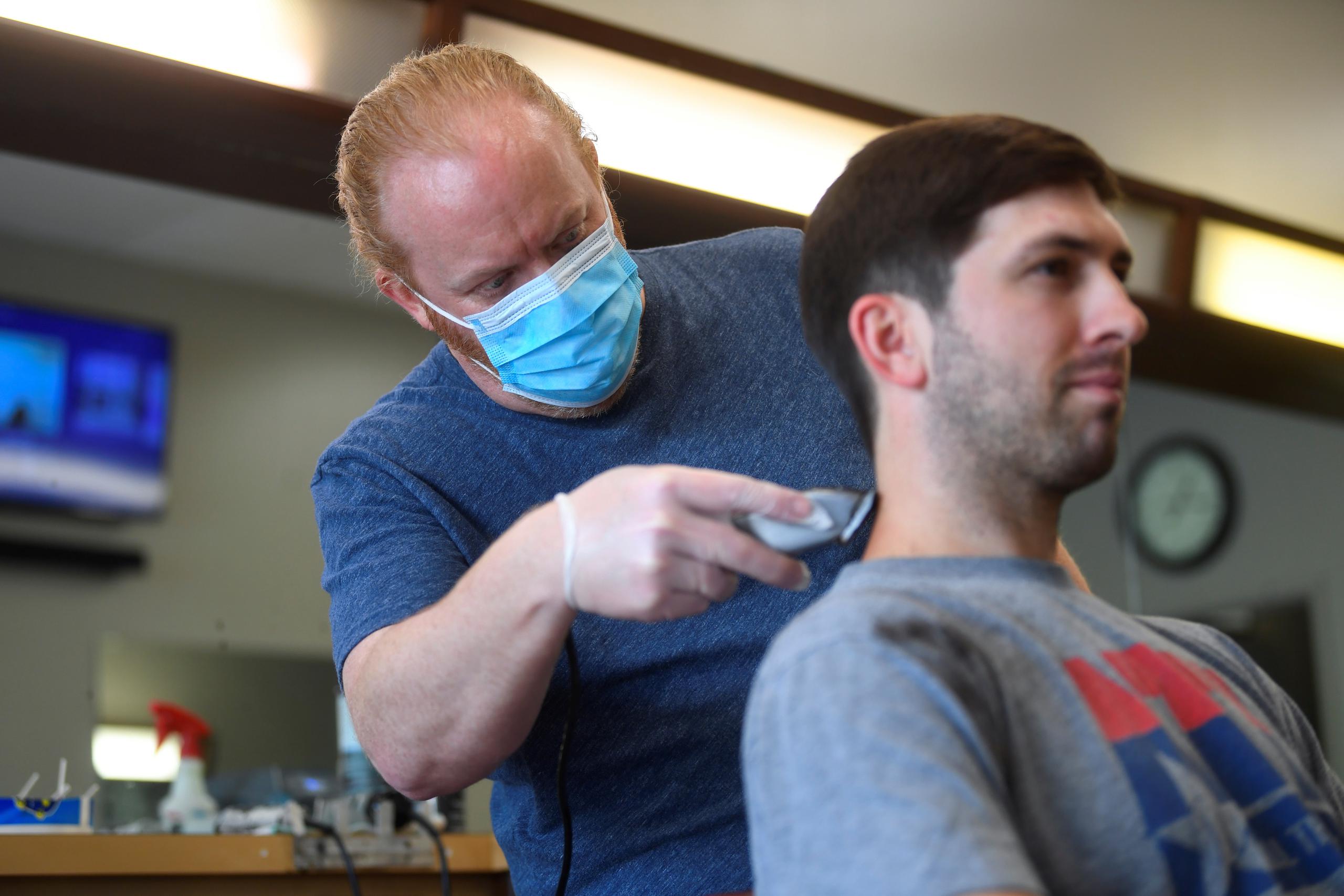 Chris Edwards recorta a un cliente en su barbería en Atlanta.