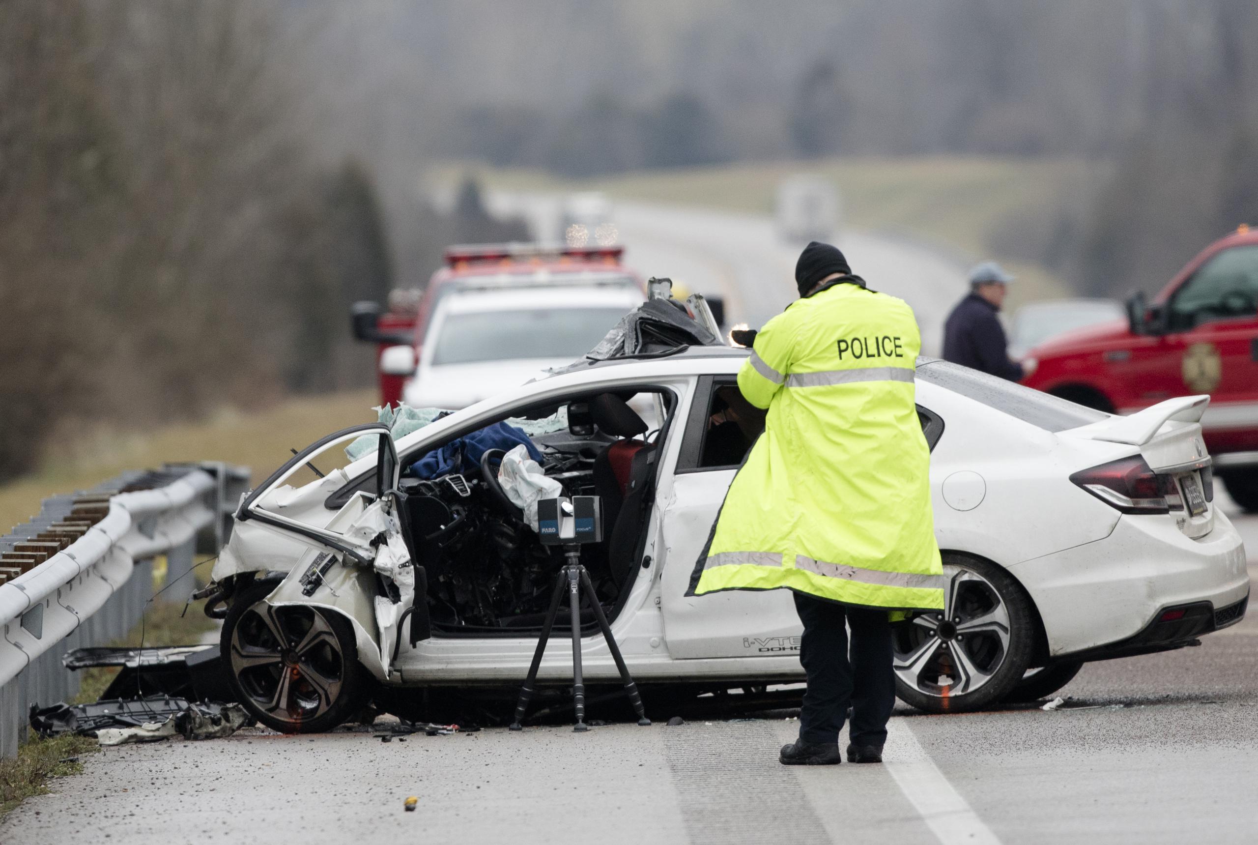 Grupos de emergencia trabajando en el lugar de una colisión fatal entre un autobús fletado y un automóvil en la carretera AA en el condado Campbell, Kentucky.