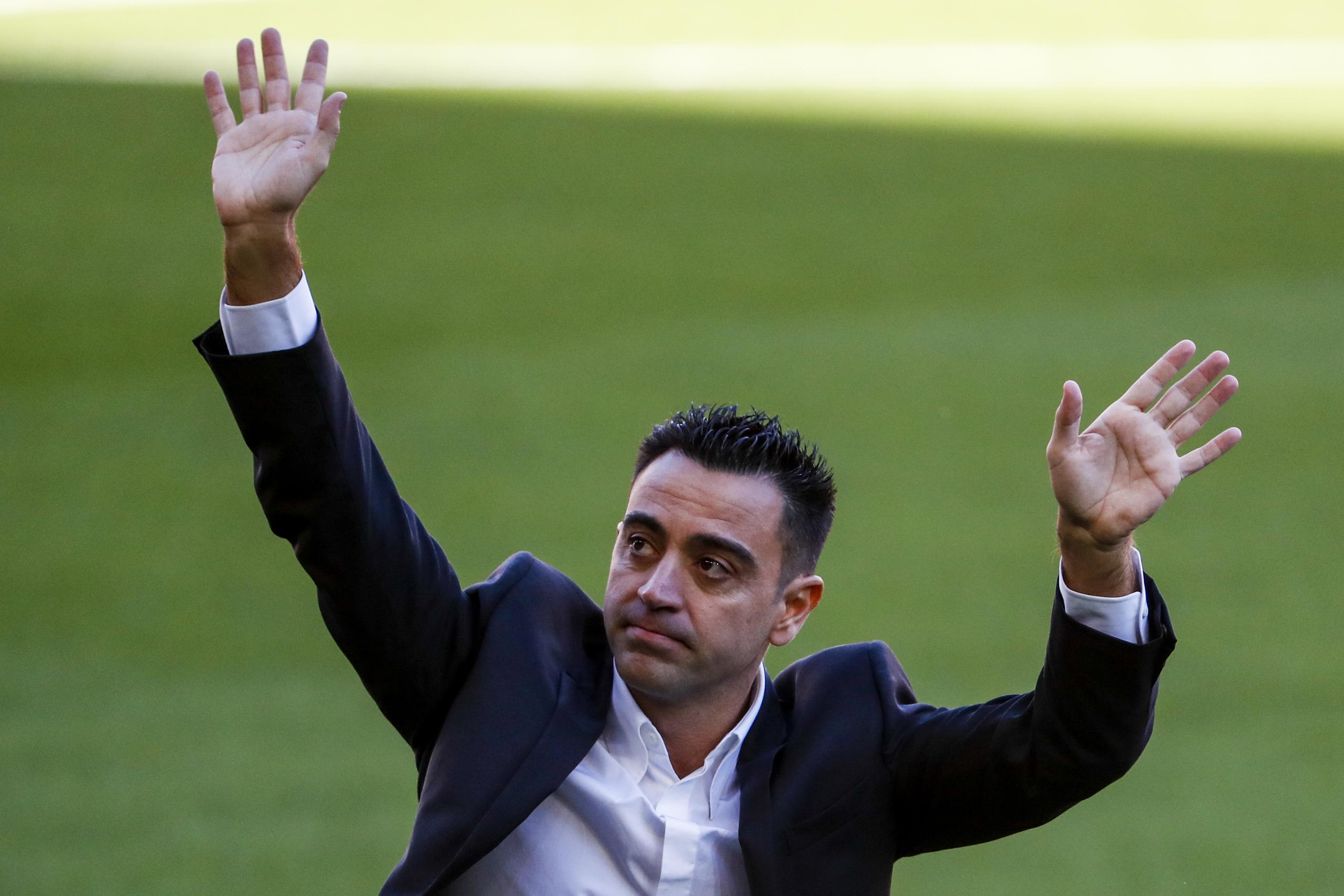 El nuevo técnico del Barcelona Xavi Hernández saluda al público en su presentación oficial.