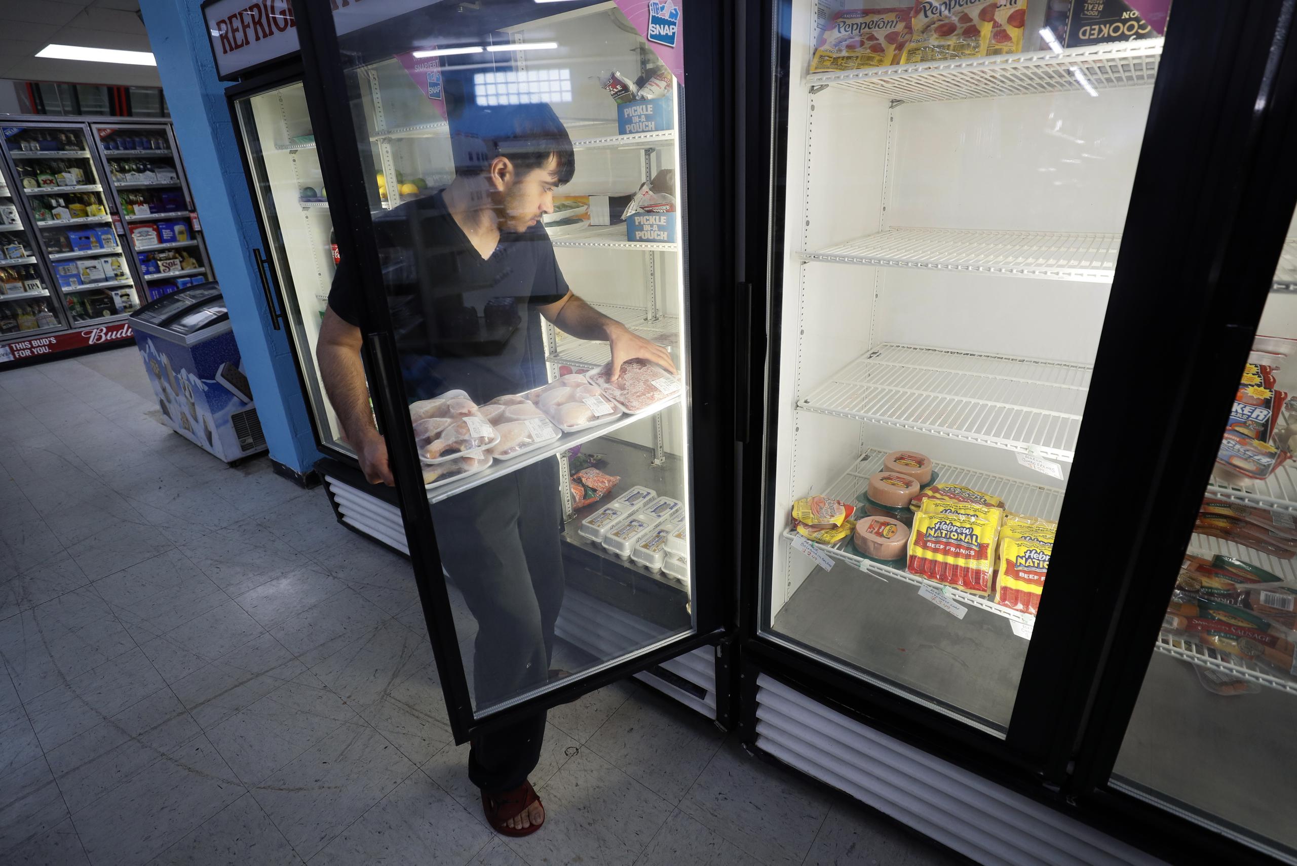 Hardik Kalra coloca carne en el refrigerador de un supermercado en Des Moines, Iowa