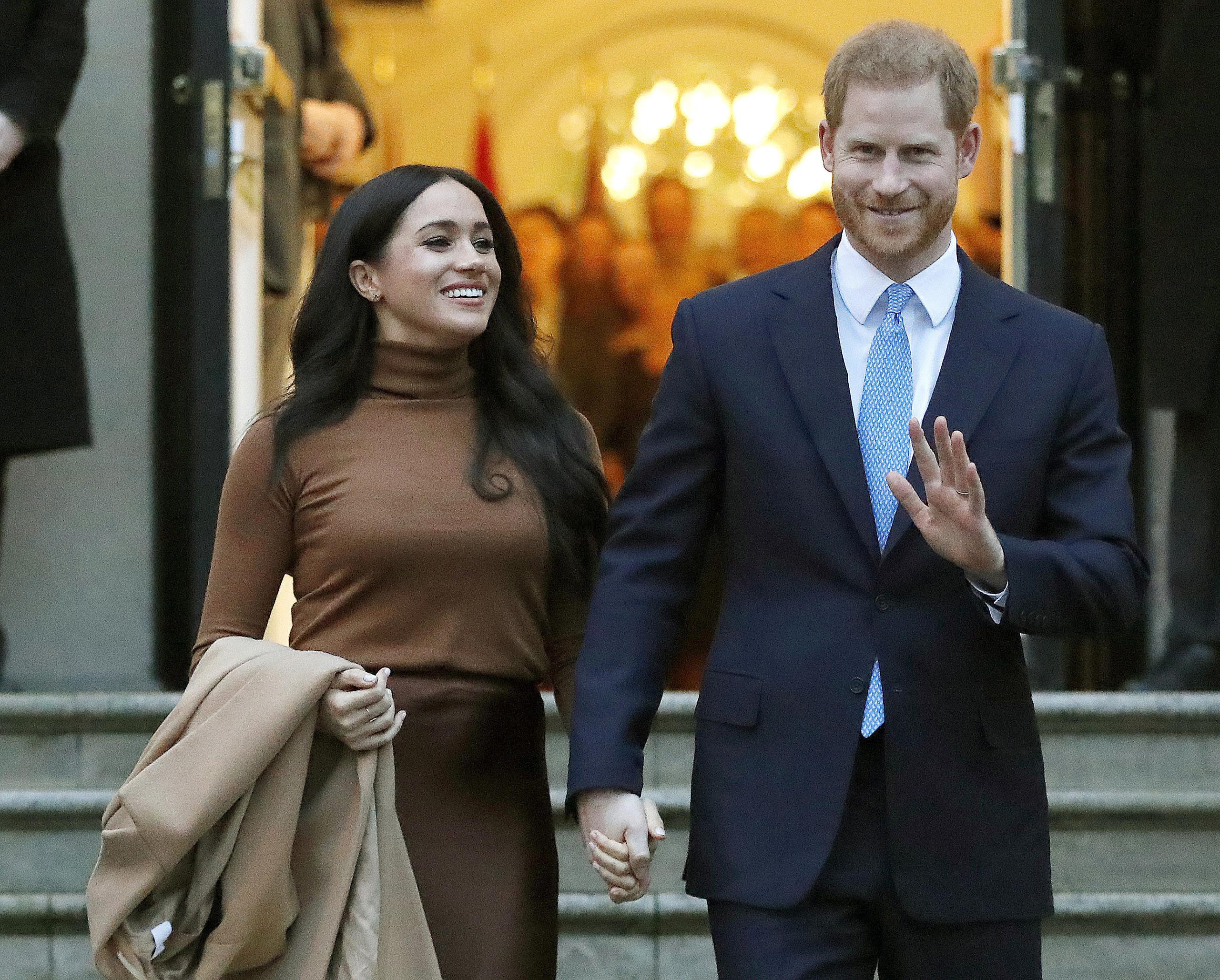 El príncipe Enrique de Inglaterra y Meghan, duquesa de Sussex, salen del Canada House en Londres.
