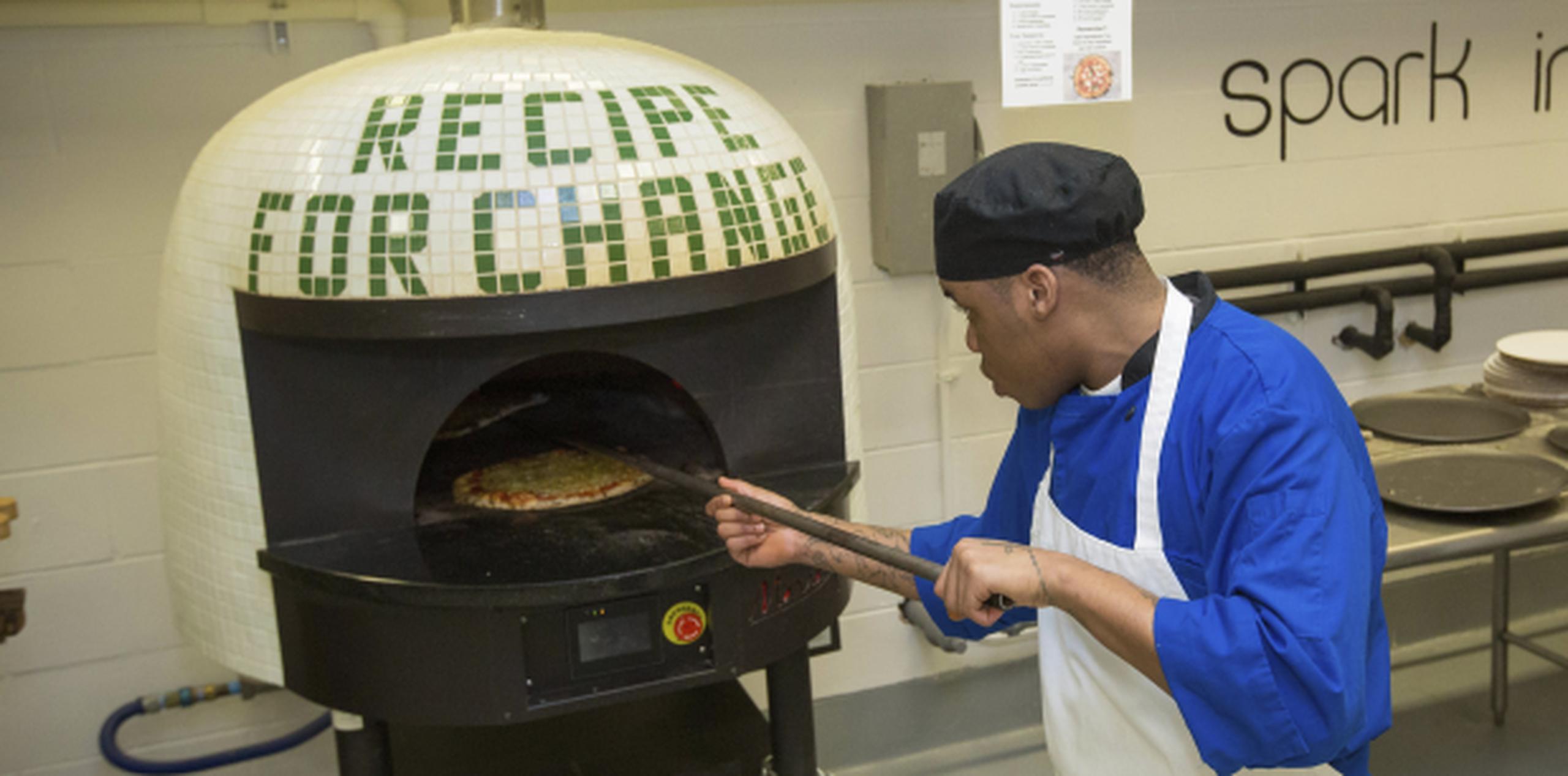 El recluso Marcus Clay sacando una pizza del horno en la cárcel. (AP / Teresa Crawford)