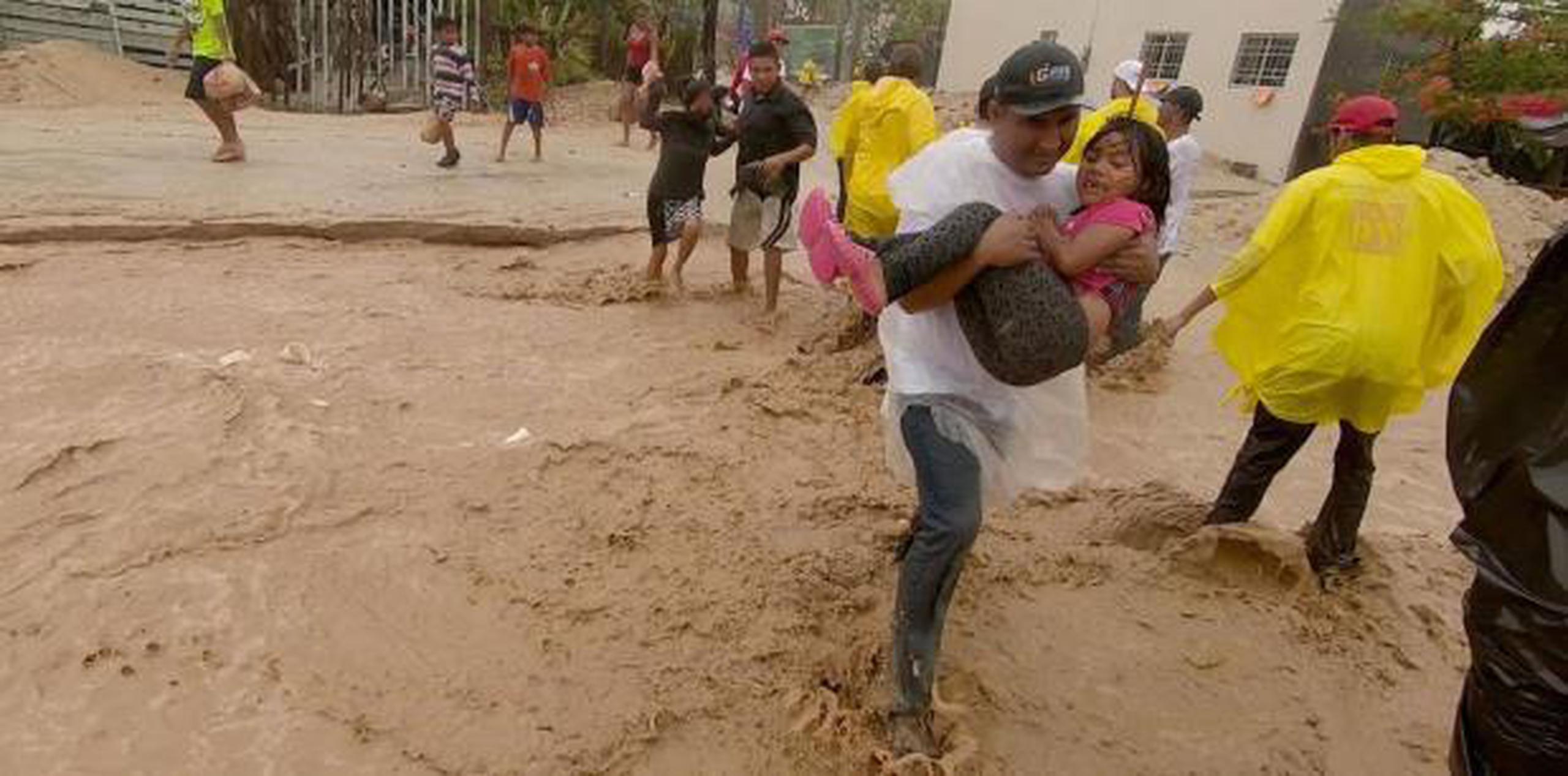 Varias personas cruzan una calle inundada tras el paso de la tormenta tropical Bud ayer, jueves, por San José del Cabo, en el estado de Baja California. (EFE / Jorge Castañeda)