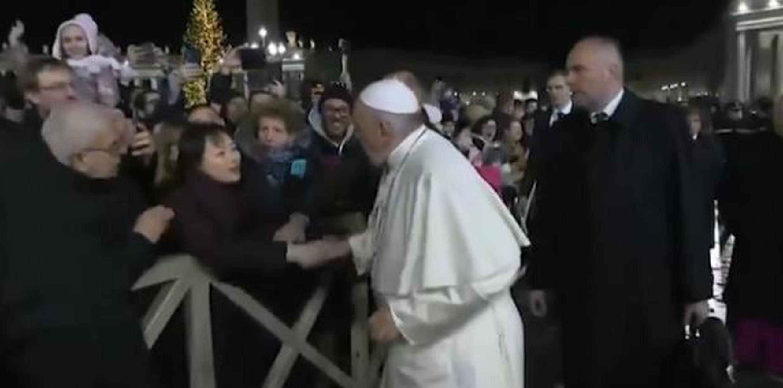 Las cámaras capturaron el momento cuando la mujer agarró la mano del papa. (Twitter)
