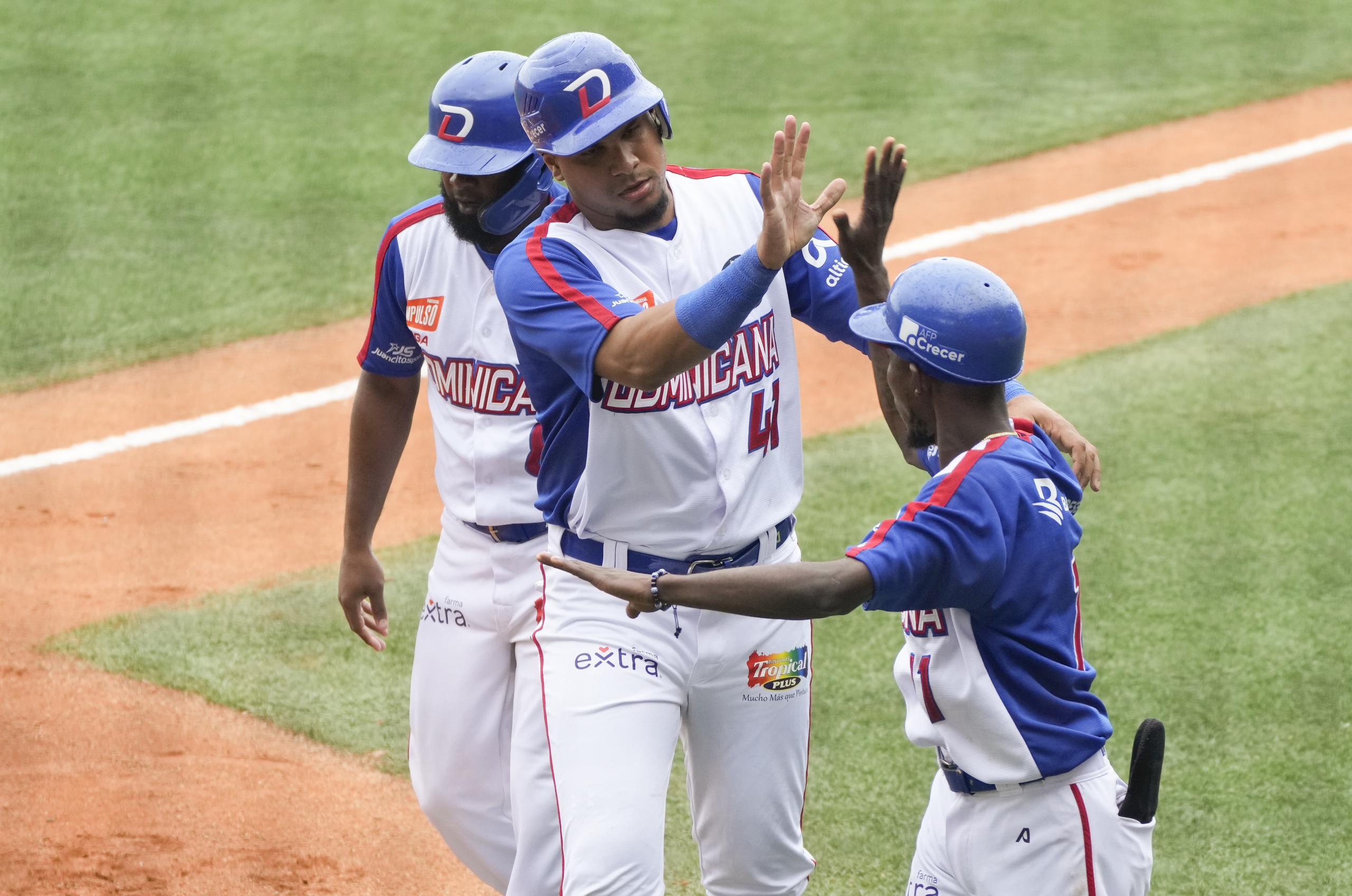 Ramón Hernández, al centro, celebra una de las carreras de República Dominicana el sábado sobre Puerto Rico en la Serie del Caribe.
