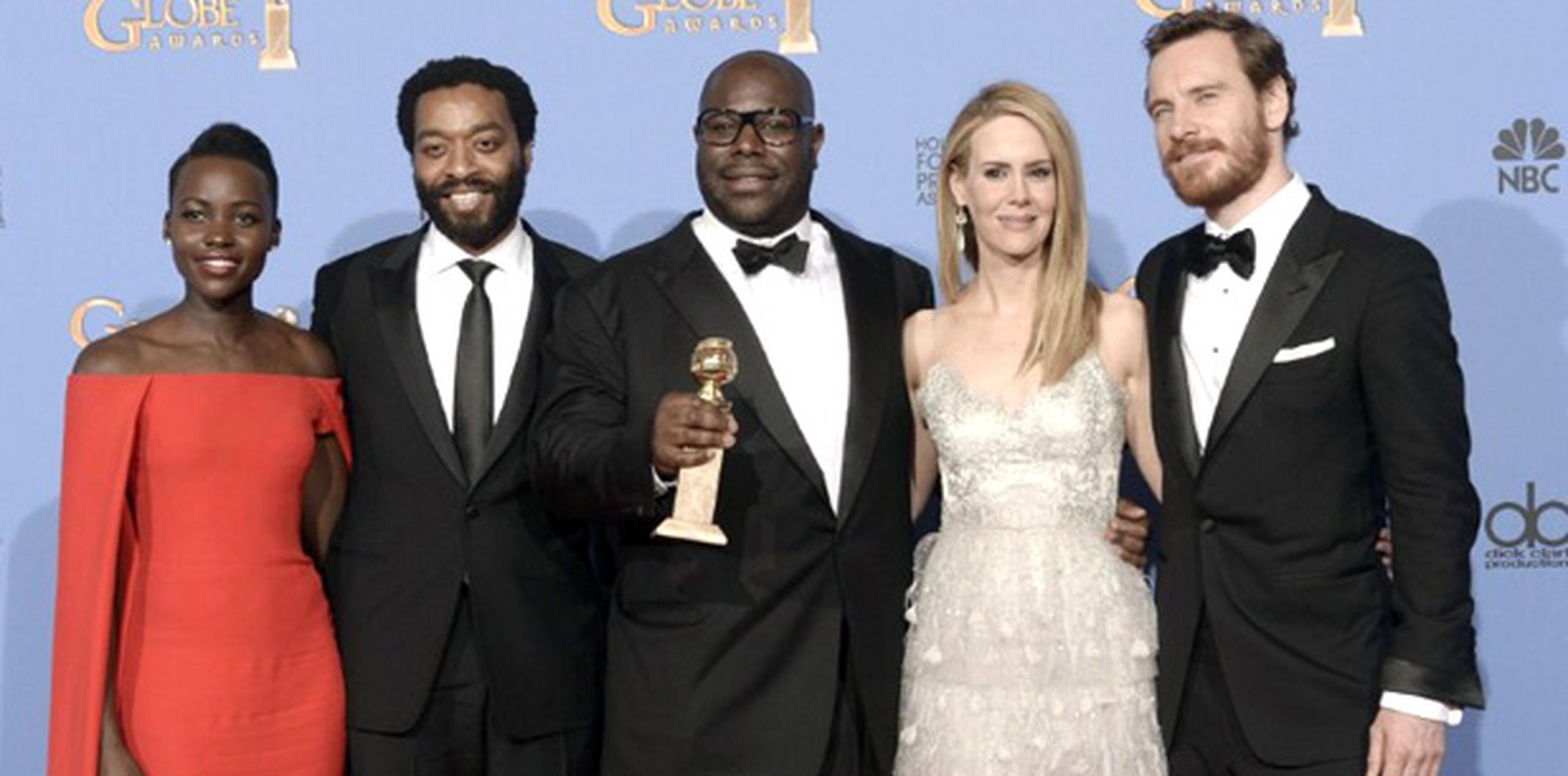 Los actores Lupita Nyong'o, Chiwetel Ejiofor, Sarah Paulson y Michael Fassbender rodean al director Steve McQueen quien sostiene el premio Globo de Oro al mejor drama que anoche ganó el filme 12 Years a Slave. (AFP)