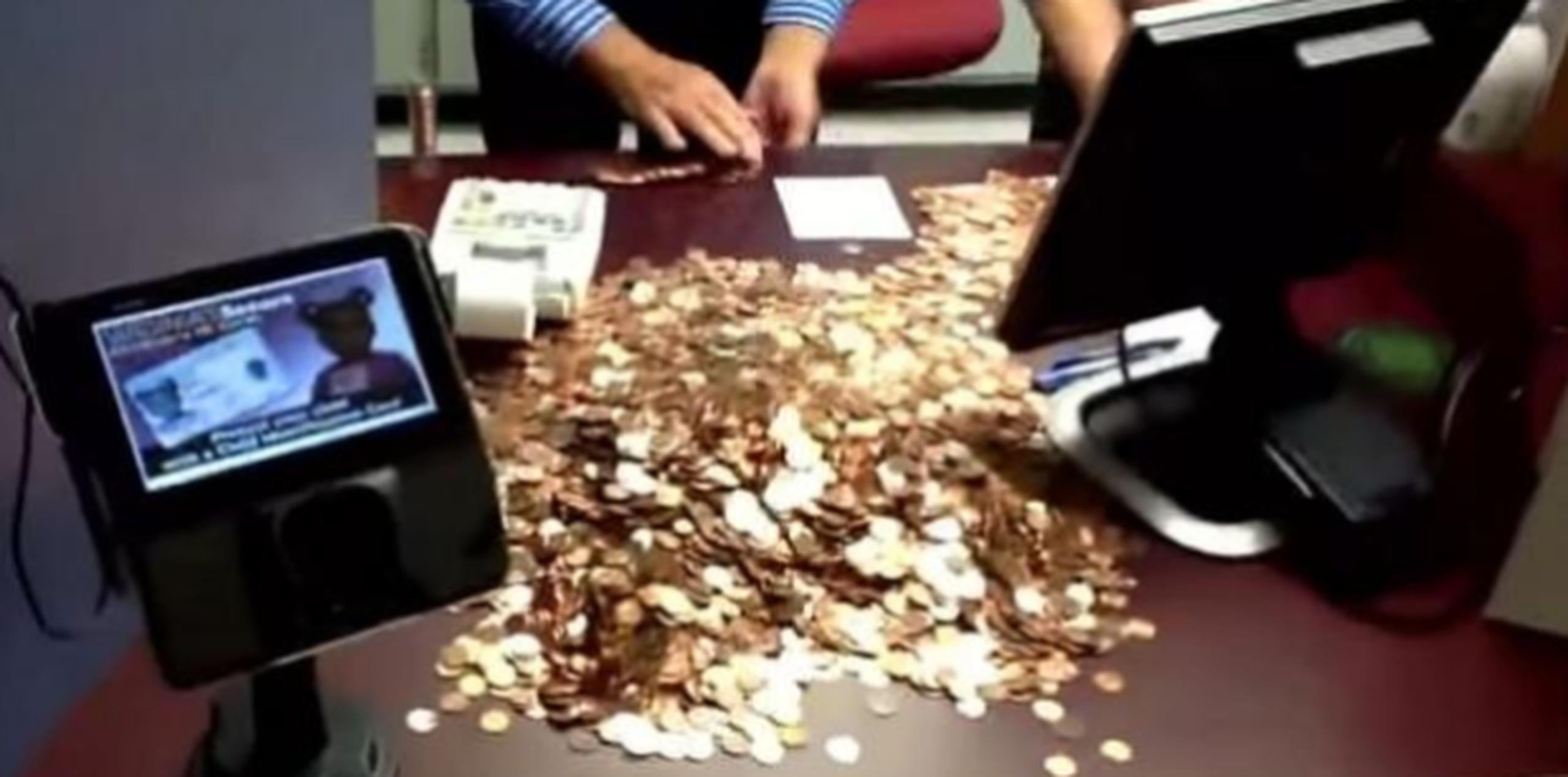 Como se ve en el vídeo de YouTube, este hombre llegó al Departamento de Vehículos Motorizados con cinco carretillas cargadas de monedas de un céntimo para pagar los $2,987 que debía. (Captura / YouTube)