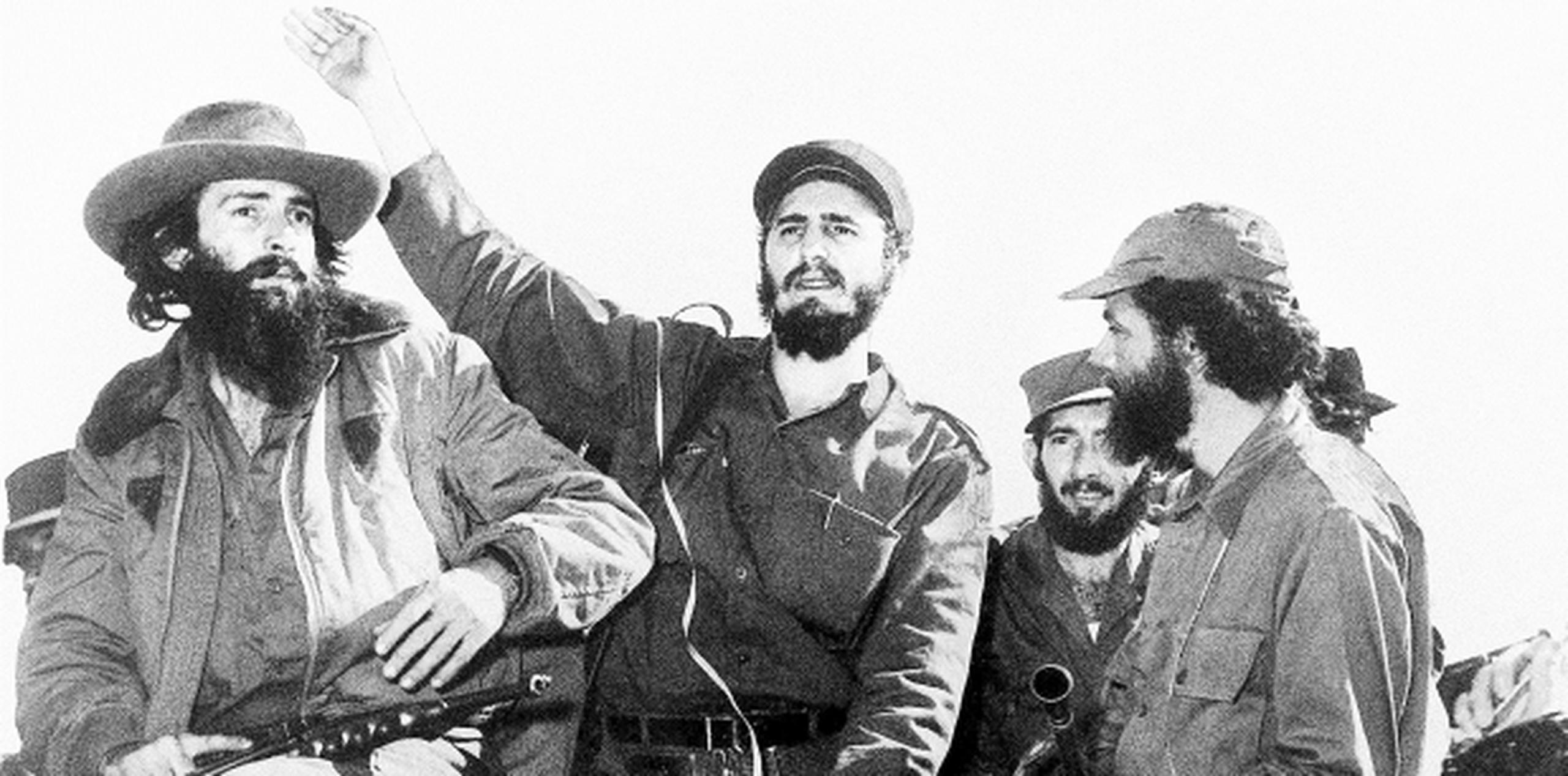 Fidel Castro entre otros líderes de la Revolución Cubana, Camilo Cienfuegos (a su izquierda) y Huber Matos (a su derecha), saluda desde un jeep a su entrada a La Habana en enero de 1959, luego de la victoria sobre las fuerzas de Fulgencio Batista. (Archivo)
