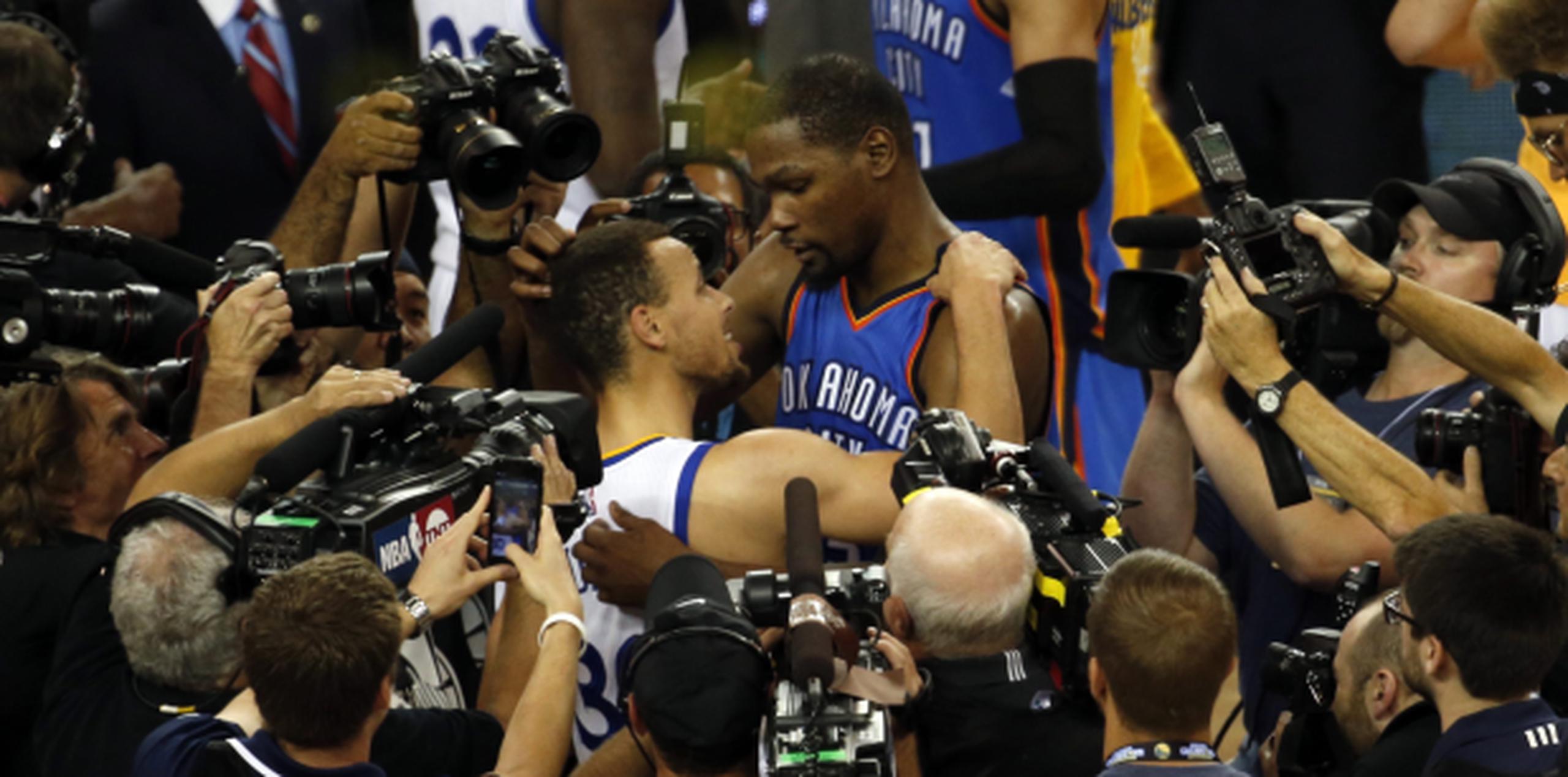 Curry y Durant se abrazan luego de finalizar la competitiva serie a favor de los Warriors. (Prensa Asociada)