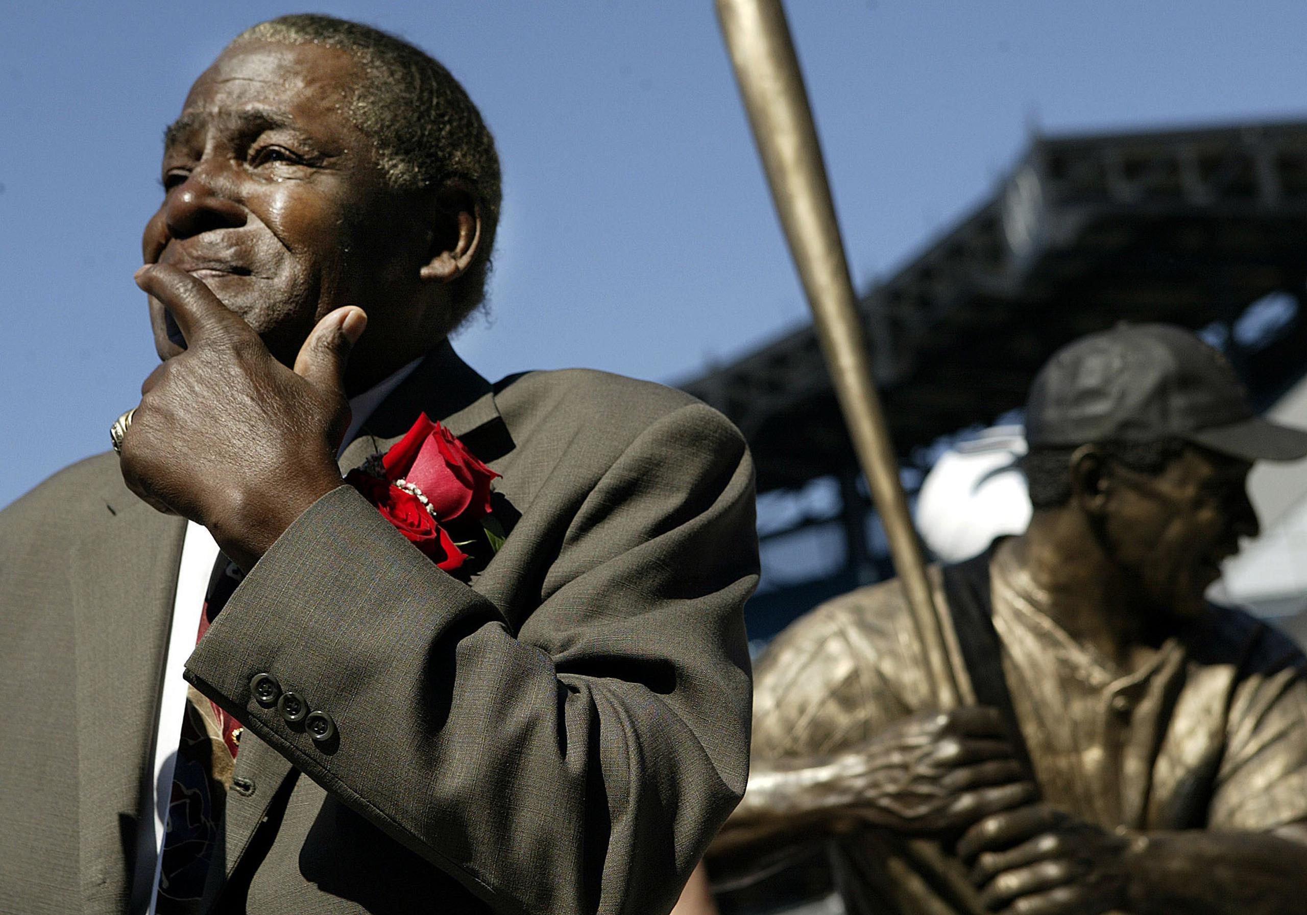 Foto de 2004 en la que Minnie Miñoso posa junto a su estatua en el estadio de los Medias Blancas de Chicago, equipo con el que debutó en 1951.