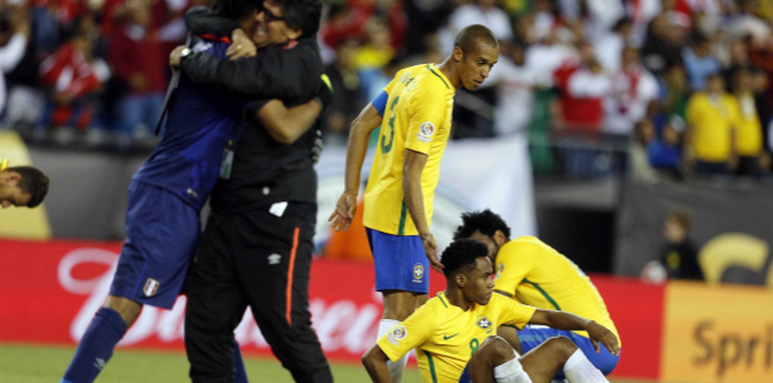 Jugadores brasileños se desploman en el campo sumidos en pena tras ser eliminados, mientras se desata la eufórica celebración de los miembros del equipo de Perú. (EFE/MAURICIO DUEÑAS CASTAÑEDA)
