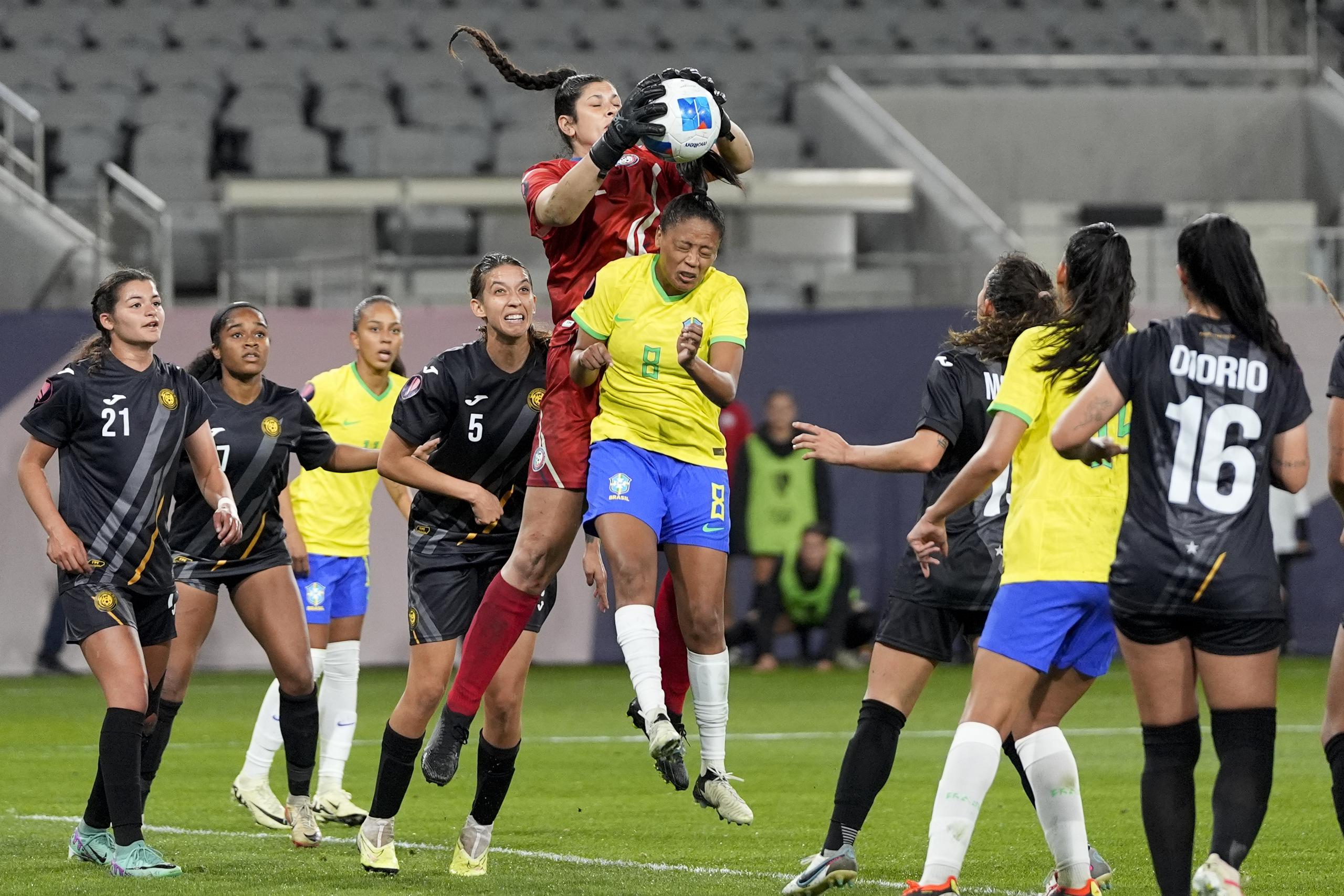 La portera de Puerto Rico, Sydney Martínez, agarra una pelota por arriba de Ary Borges durante la acción de la primera mitad del partido anoche.