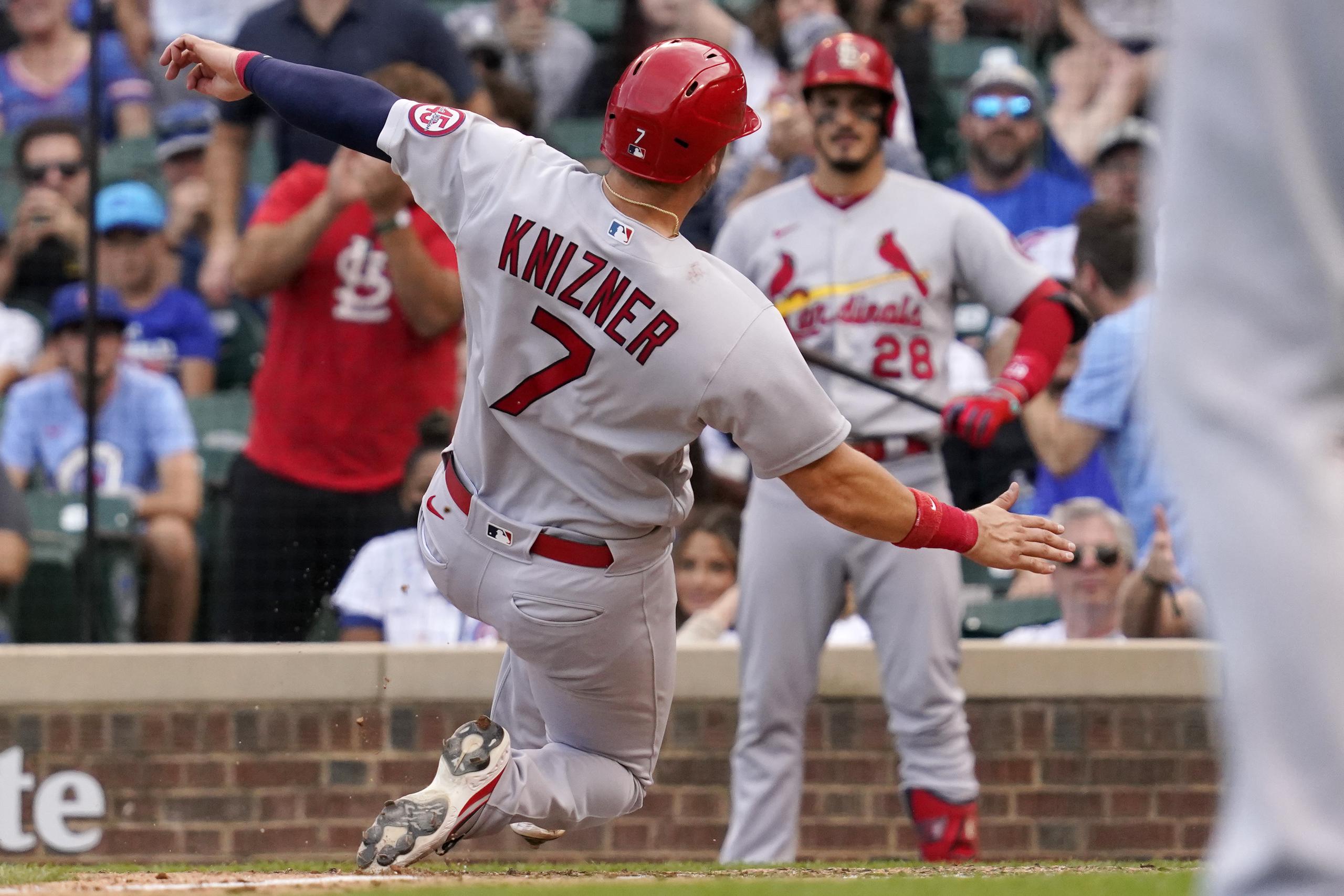 Andrew Knizner (7), de los Cardinals de San Luis, anota la carrera de la ventaja en la novena entrada gracias a un lanzamientos salvaje del relevista de los Cubs, Codi Heuer.