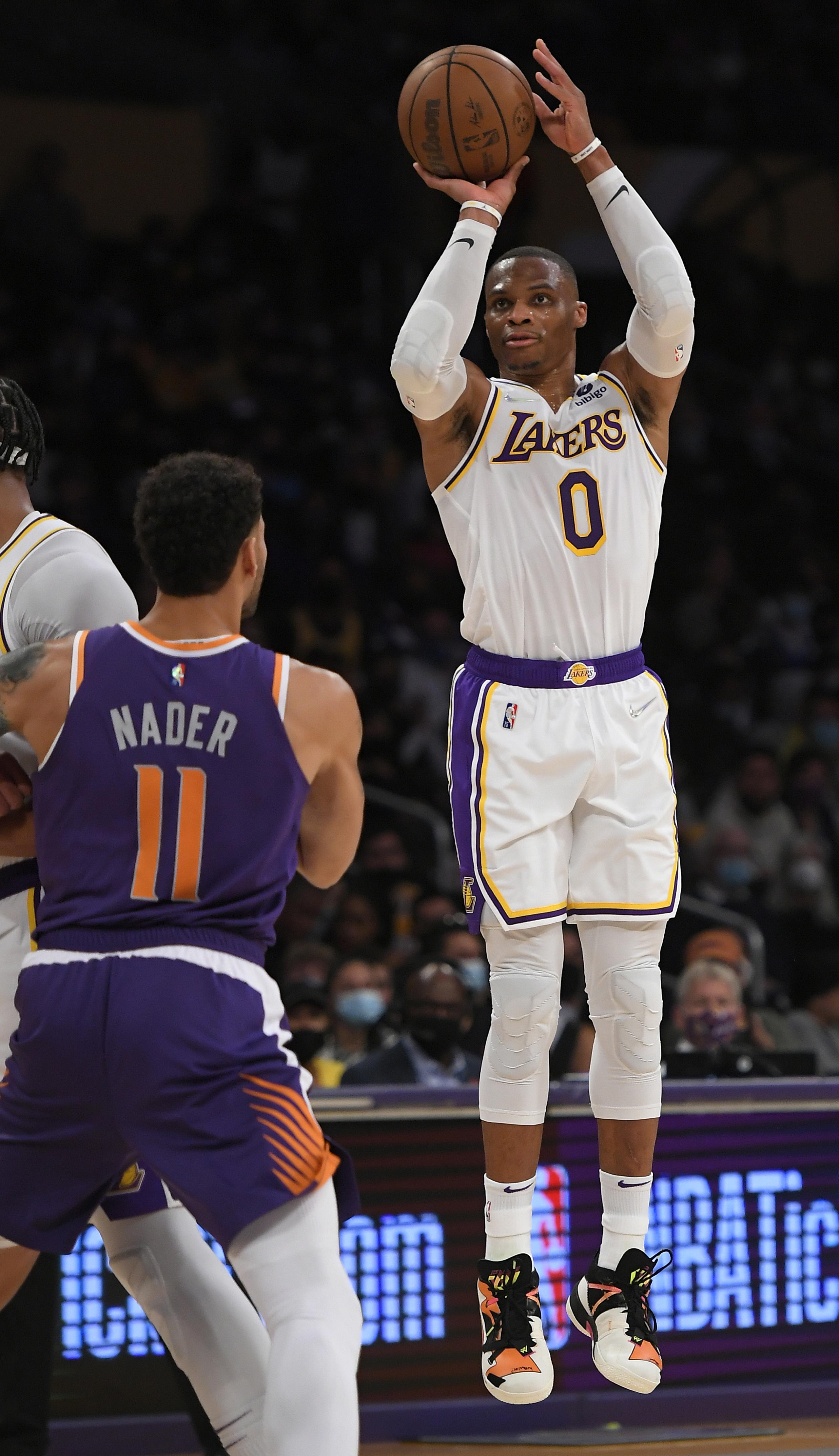 El alero de los Suns de Phoenix Abdel Nader observa mientras el base de los Lakers de Los Ángeles Russell Westbrook lanza el balón en el encuentro de pretemporada. Los Lakers están listos para buscar un campeonato con un renovado roster lleno de jugadores experimentados.
