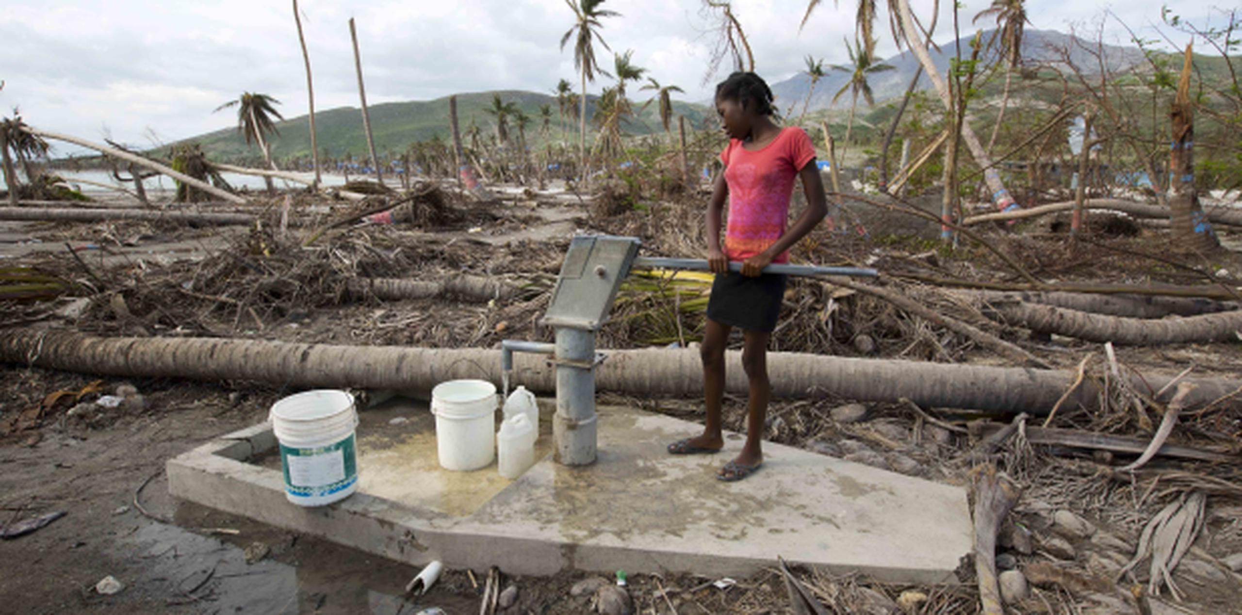 Gelene Jeudy pompea agua de un pozo contaminado en el distrito de Les Cayes. (Prensa Asociada)
