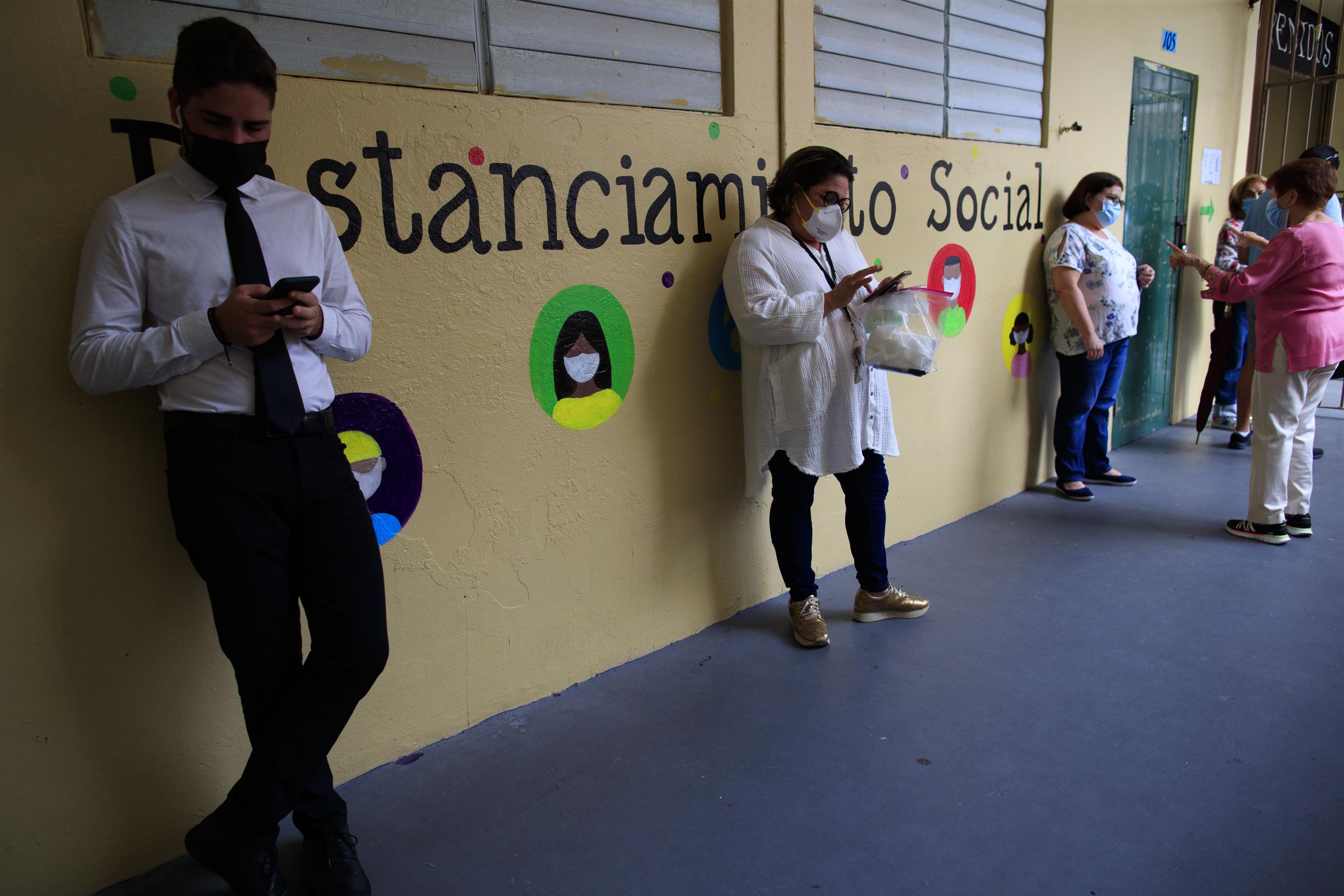Ciudadanos en la Escuela Rafael Labra, en San Juan, esperan su turno para votar..