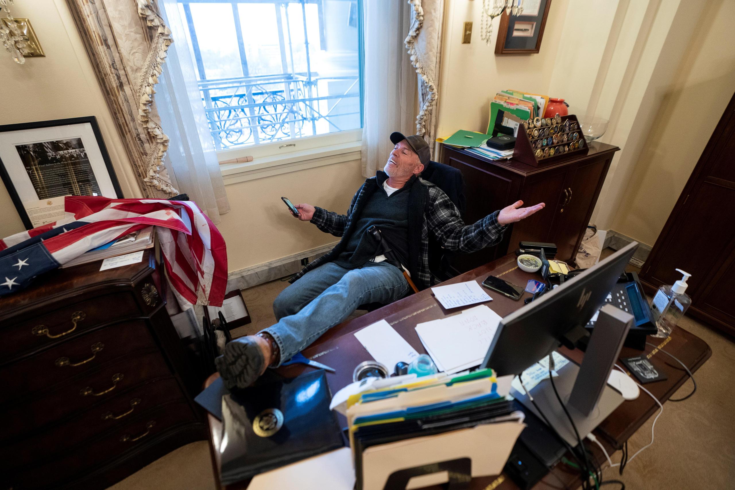 Richard Barnett se sentó en el escritorio de la presidenta de la Cámara de Representantes de Estados Unidos, Nancy Pelosi, luego de irrumpir en el Capitolio.